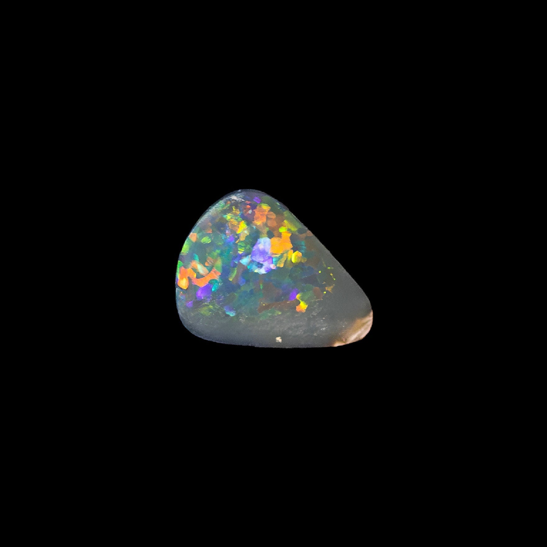 Multicolored opal stone on a black background