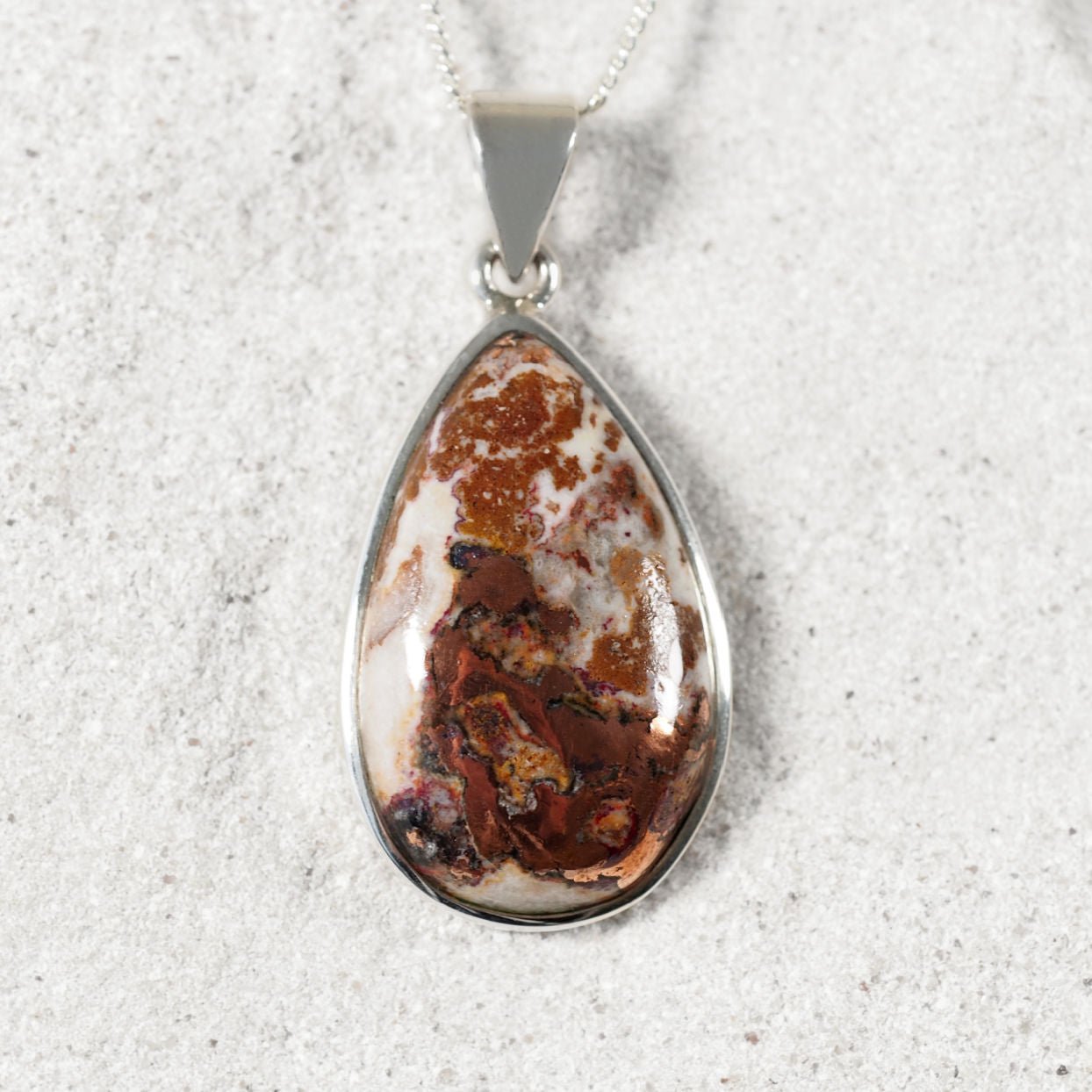 'Corina' Teardrop Copper Dolomite pendant in polished silver bezel with earthy copper, red, and white patterns