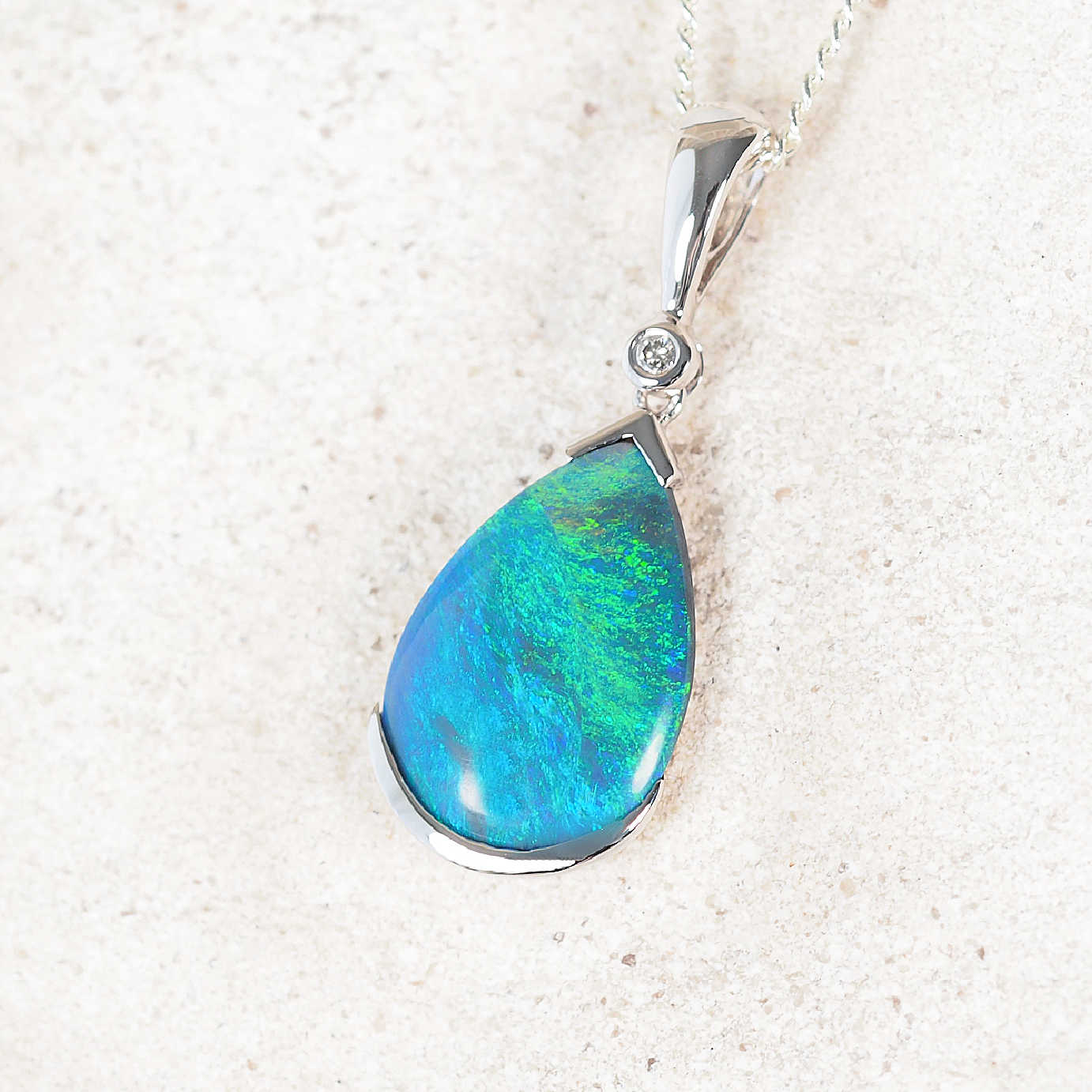 Elegant Australian black opal pendant featuring bezel-set teardrop solid opal from Lightning Ridge with diamond detail