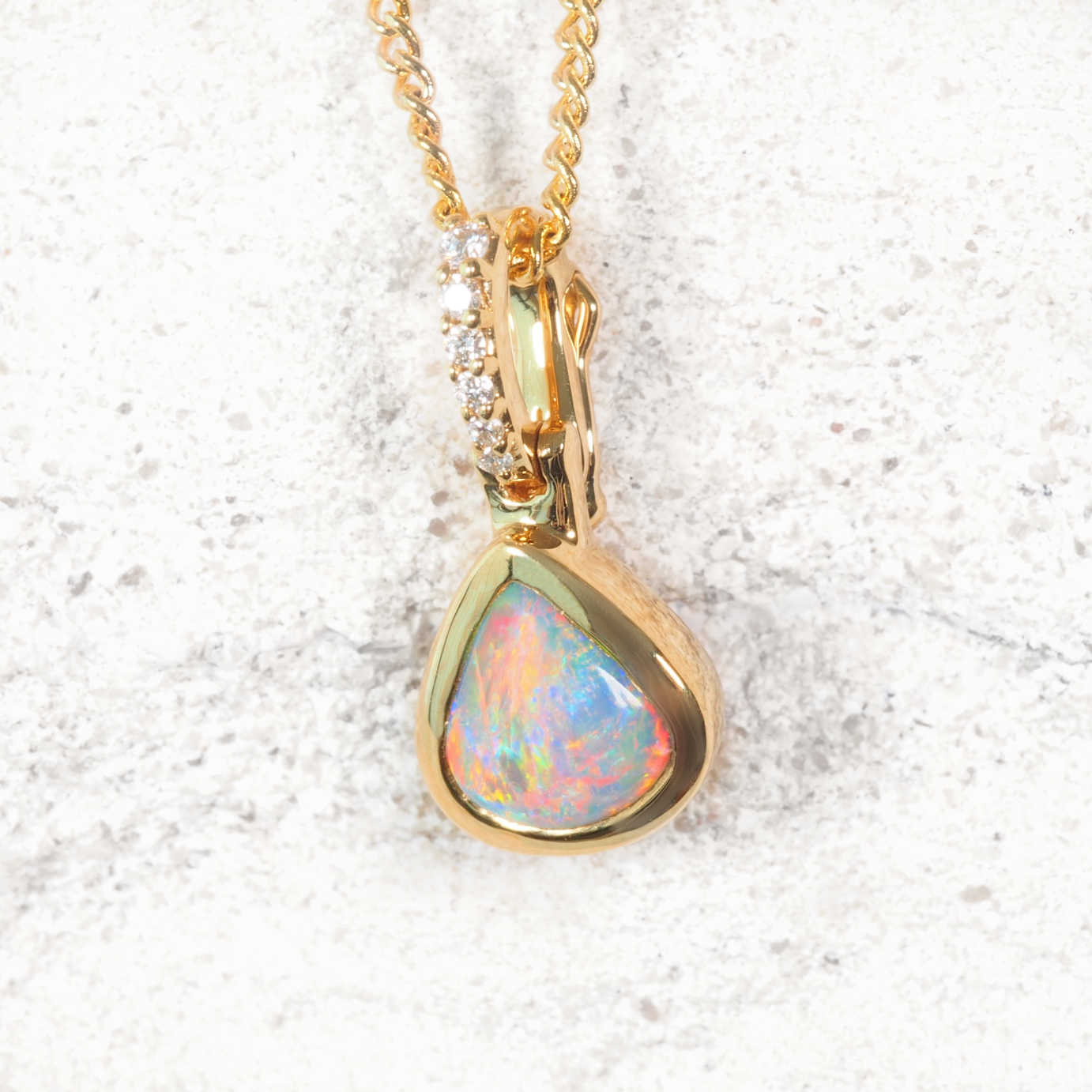 eardrop-shaped semi-black opal necklace in gold with play-of-colour