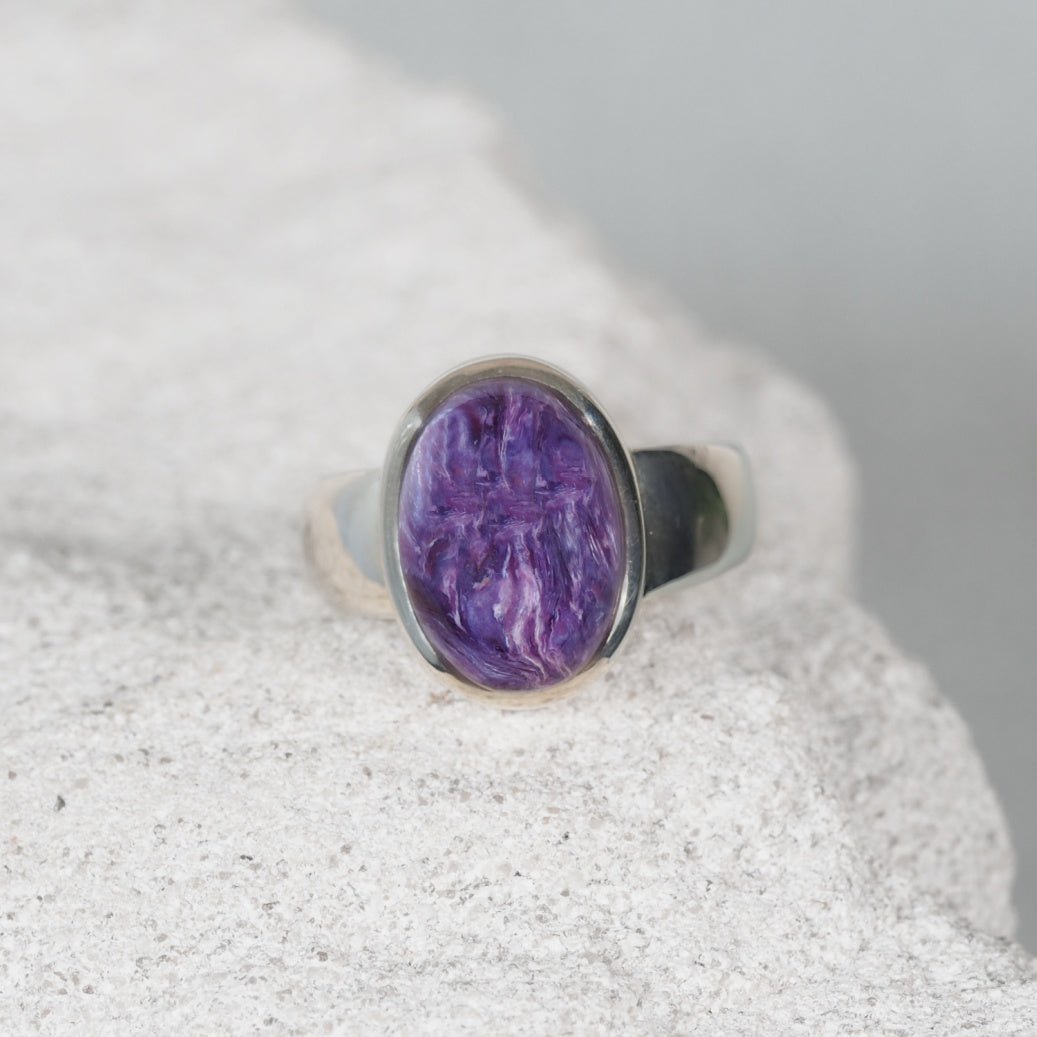 Charoite Gemstone ring displaying deep purple swirls in a silver frame