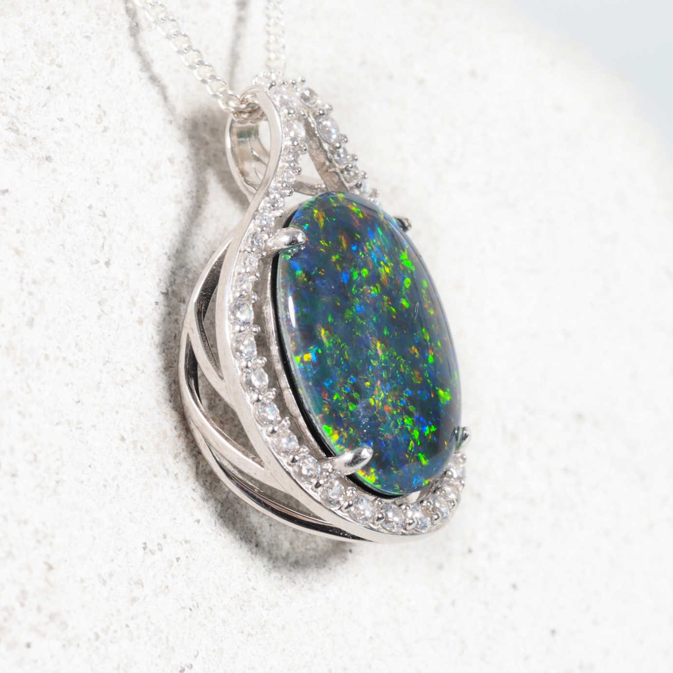 Elegant sterling silver opal pendant with oval multi-coloured Australian triplet opal surrounded by forty brilliant diamantés