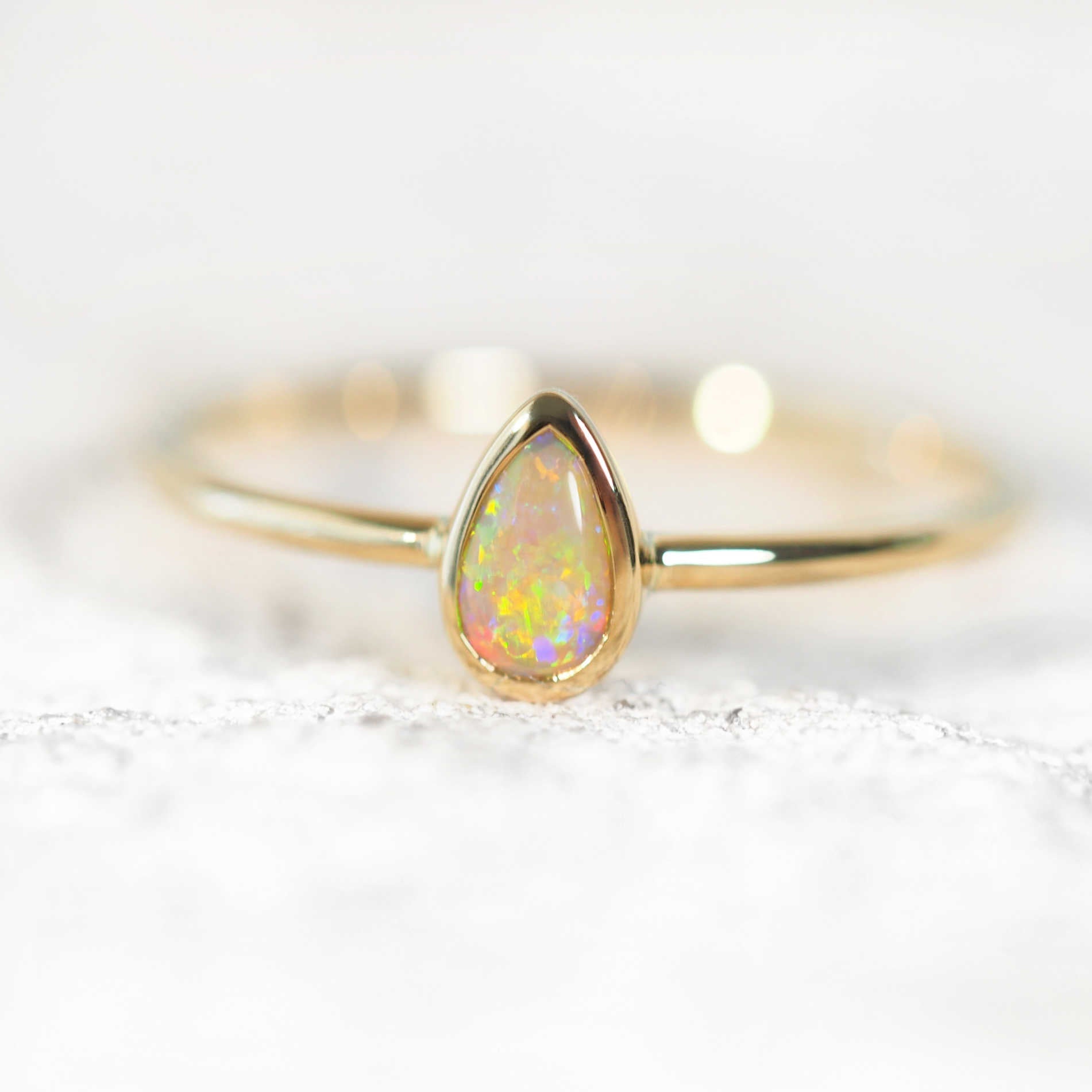teardrop-shape opal ring set in yellow gold
