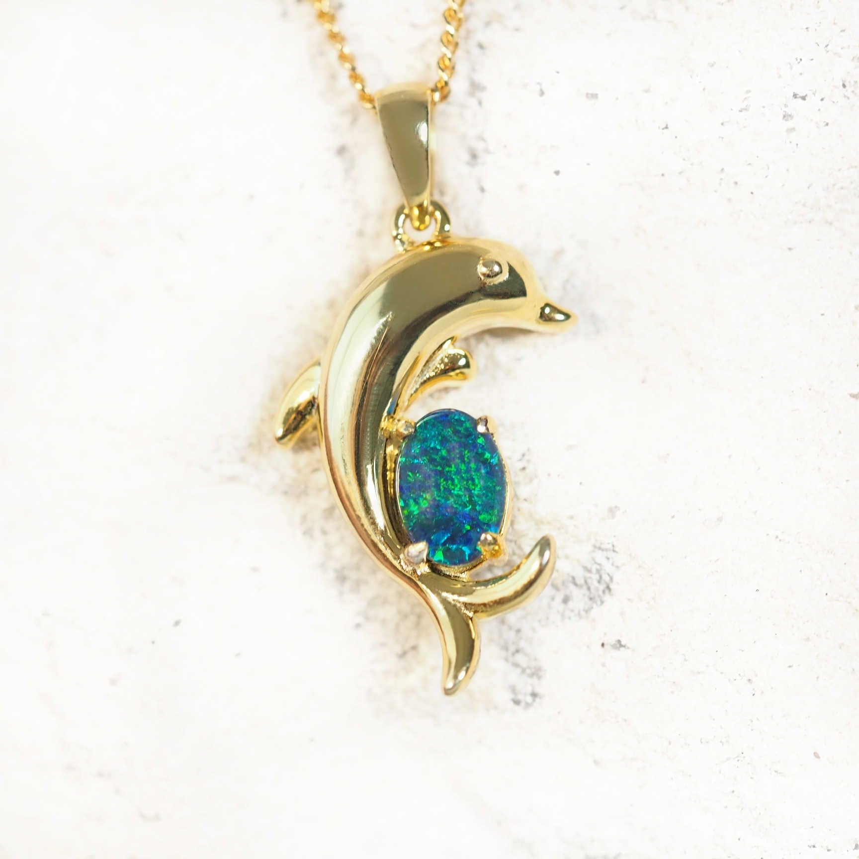Gold-plated silver dolphin opal pendant necklace with claw-set blue and green Australian triplet opal, shown with matching chain.