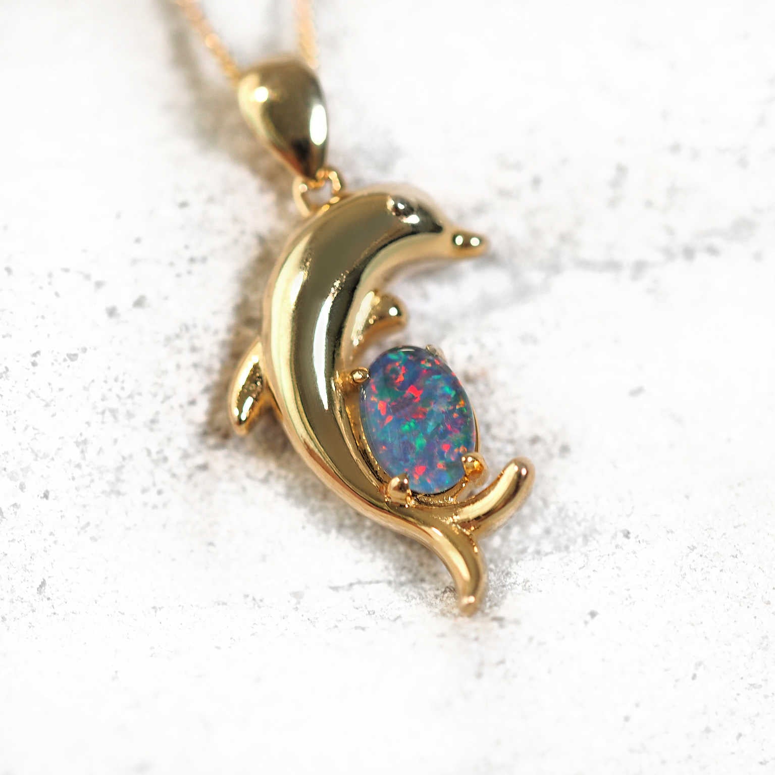 Gold-plated silver dolphin-shaped opal pendant necklace with claw-set multi-coloured Australian triplet opal, shown with matching chain.