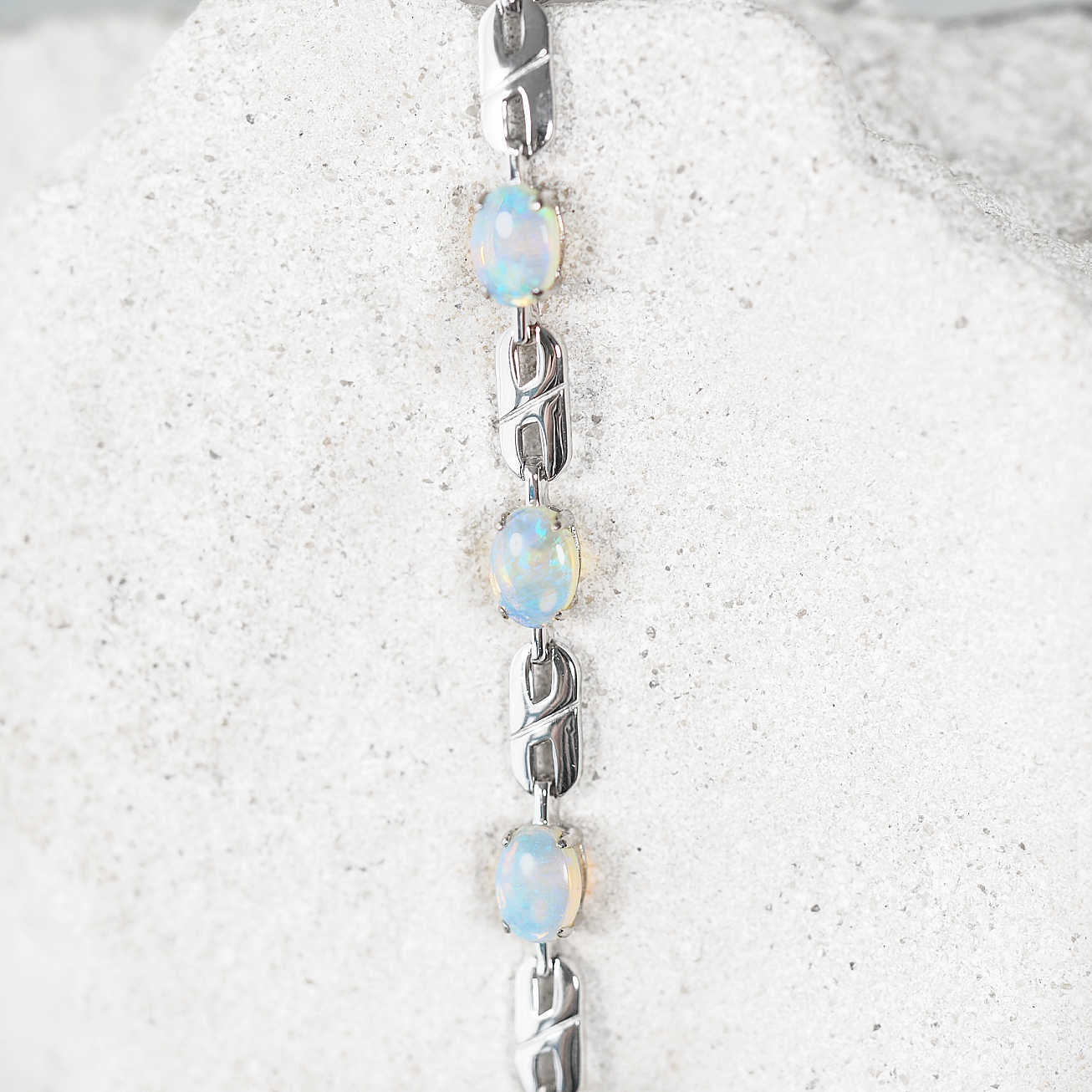 Silver bracelet with Australian solid crystal opal stones on a textured white background