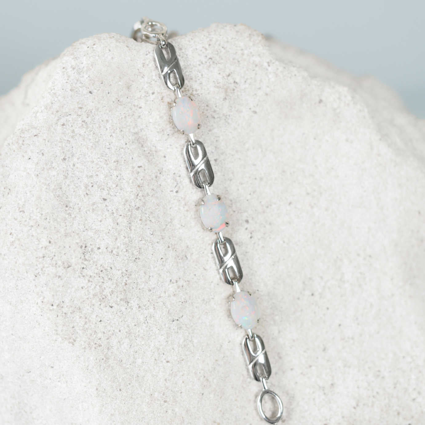 Bracelet with solid opal gemstones and silver links on a textured surface