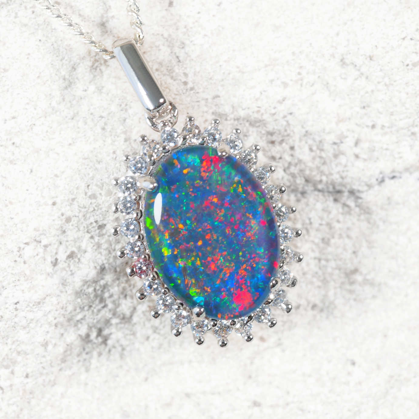 Statement sterling silver opal necklace pendant featuring colourful oval Australian triplet opal surrounded by 26 cubic zirconias