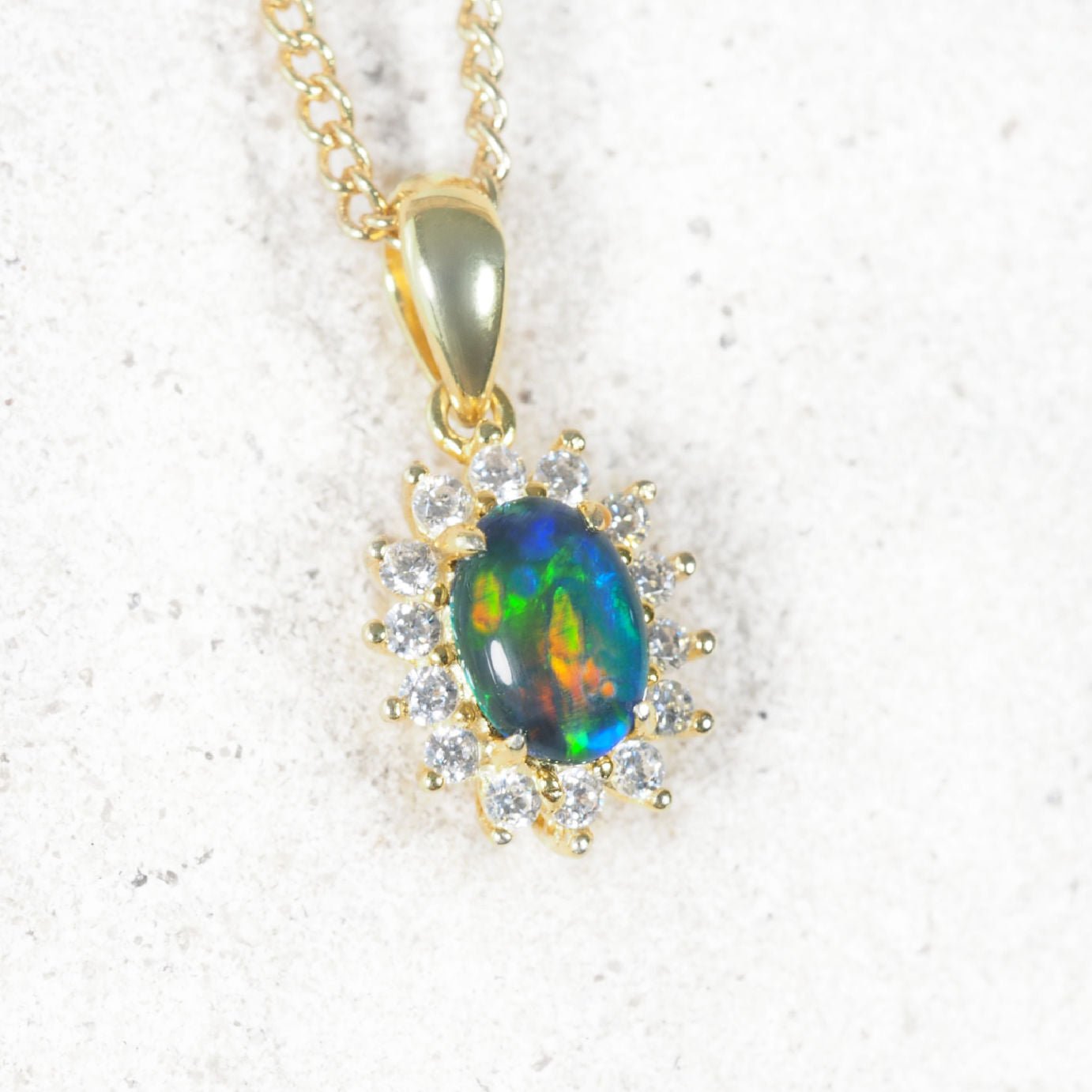 'Duchess' opal pendant in gold-plated silver with claw-set oval Australian triplet opal and halo of 14 sparkling cubic zirconias