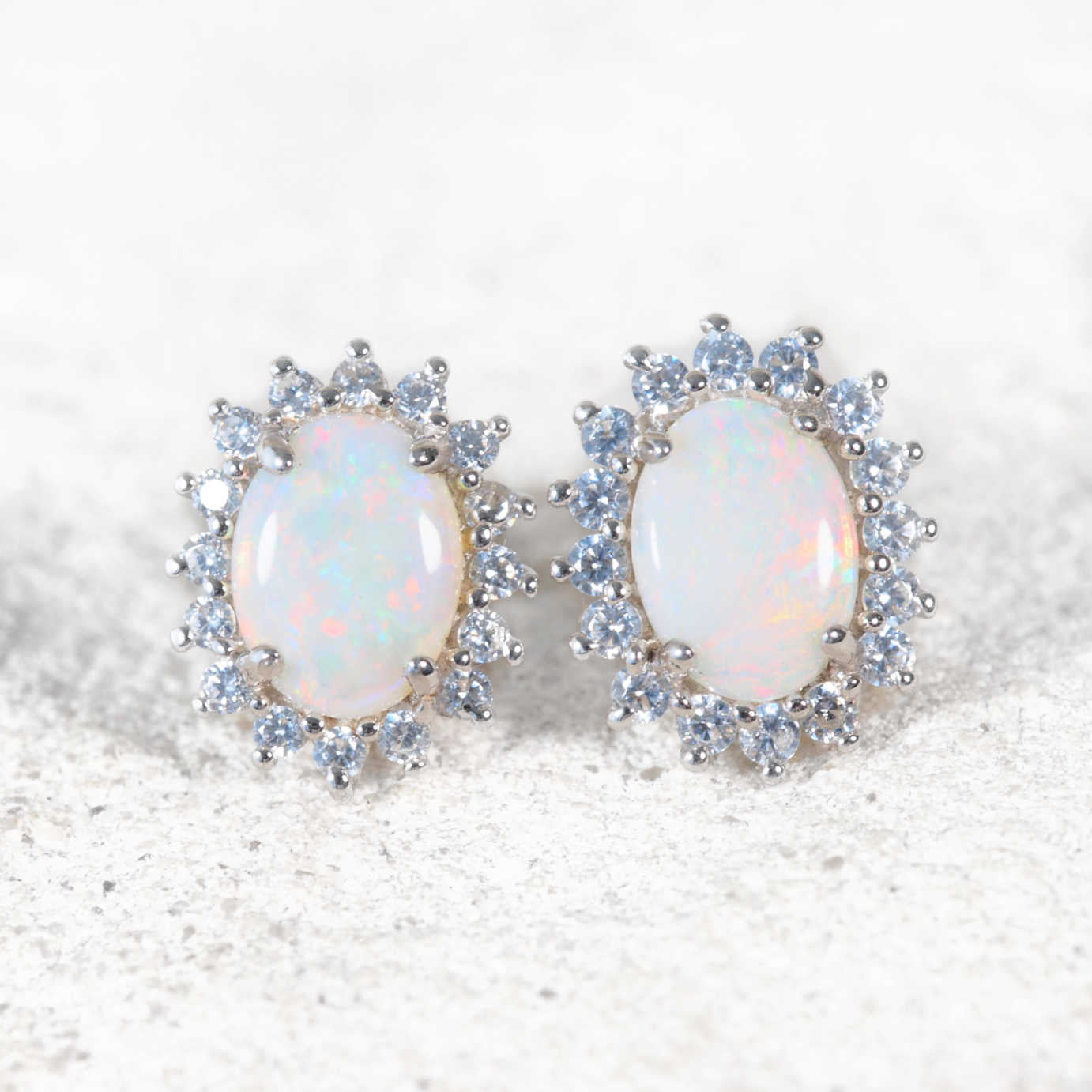 These dazzling sterling silver stud opal earrings feature multi-coloured, oval-shaped South Australian solid white opals