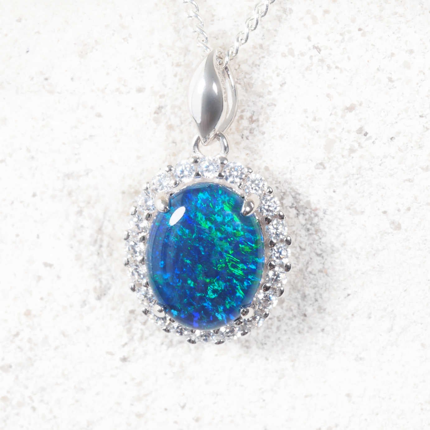 Blue opal pendant with silver chain on a white background
