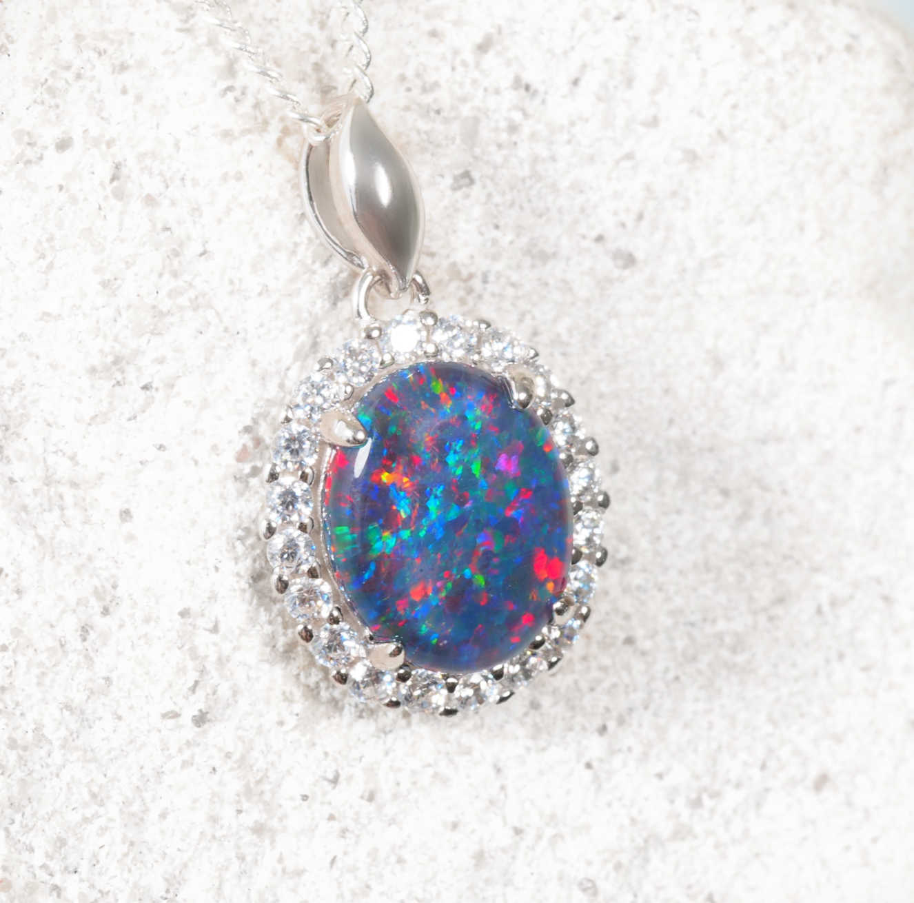 Dazzling opal pendant with silver setting on a white background
