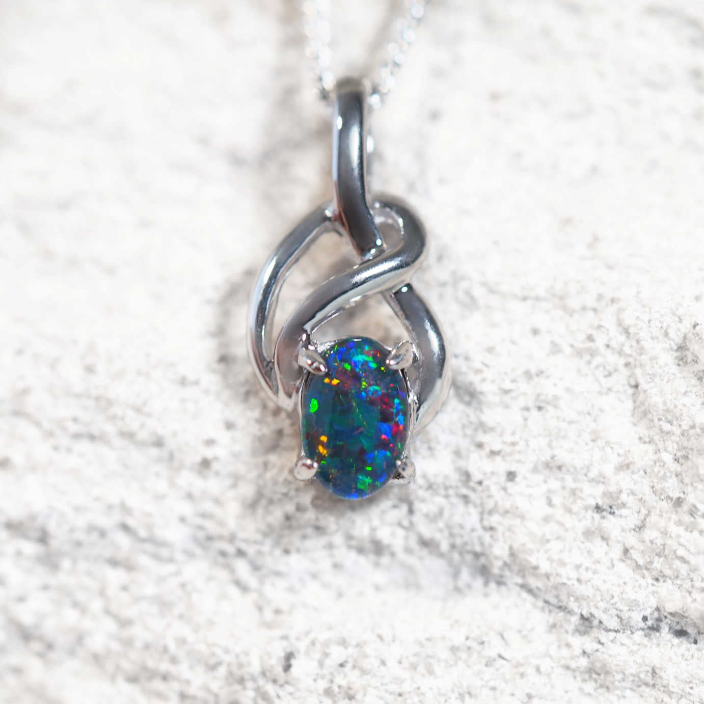 Eira opal pendant in sterling silver with Celtic twist design and claw-set oval Australian triplet opal in vibrant multi-coloured tones