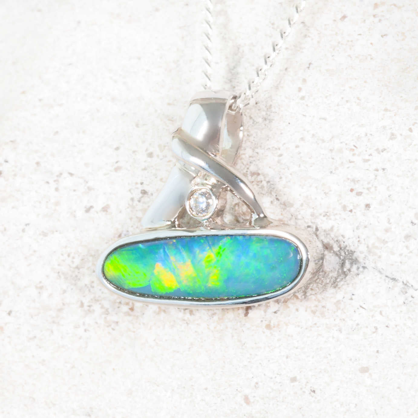 Opal pendant with silver setting on a white background
