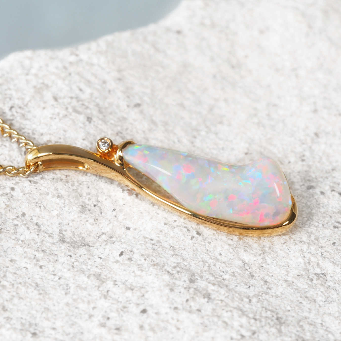 Opal pendant necklace on a textured surface