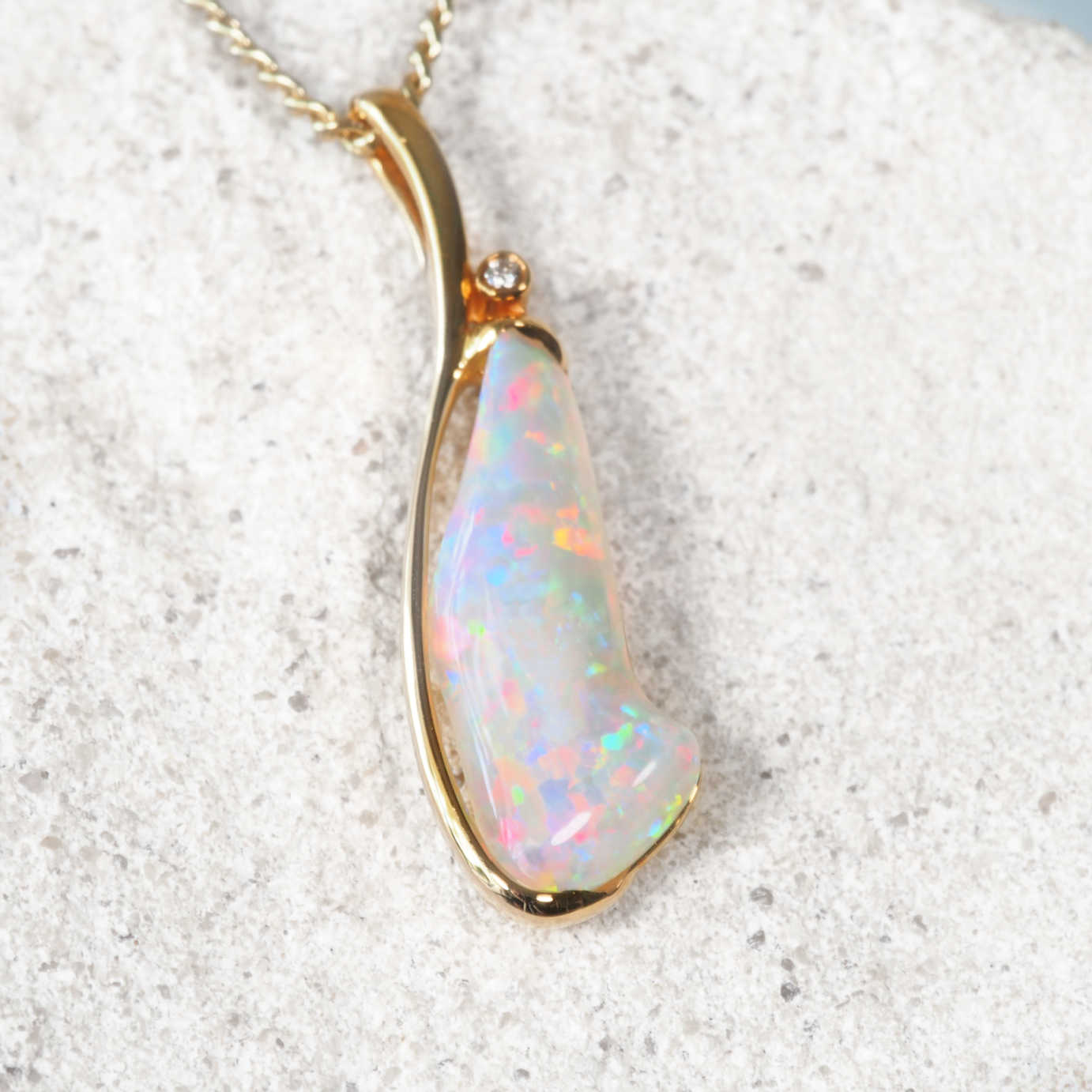Opal pendant necklace on a textured white background