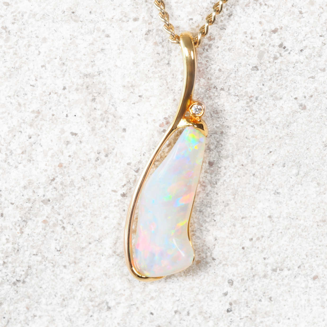 Coober Pedy opal pendant necklace on a textured white background