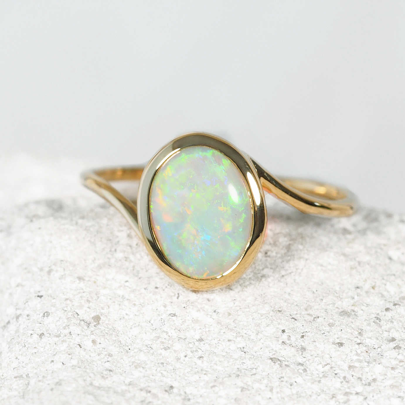 Luxury Australian crystal opal ring crafted in solid 14ct yellow gold with an oval bezel-set Coober Pedy opal