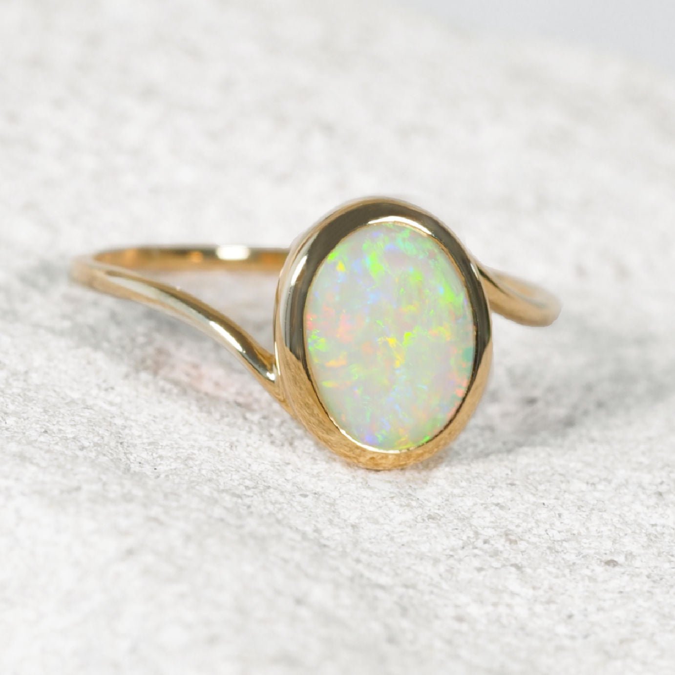 14ct yellow gold Australian crystal opal ring featuring a genuine oval Coober Pedy solid opal in a polished bezel setting