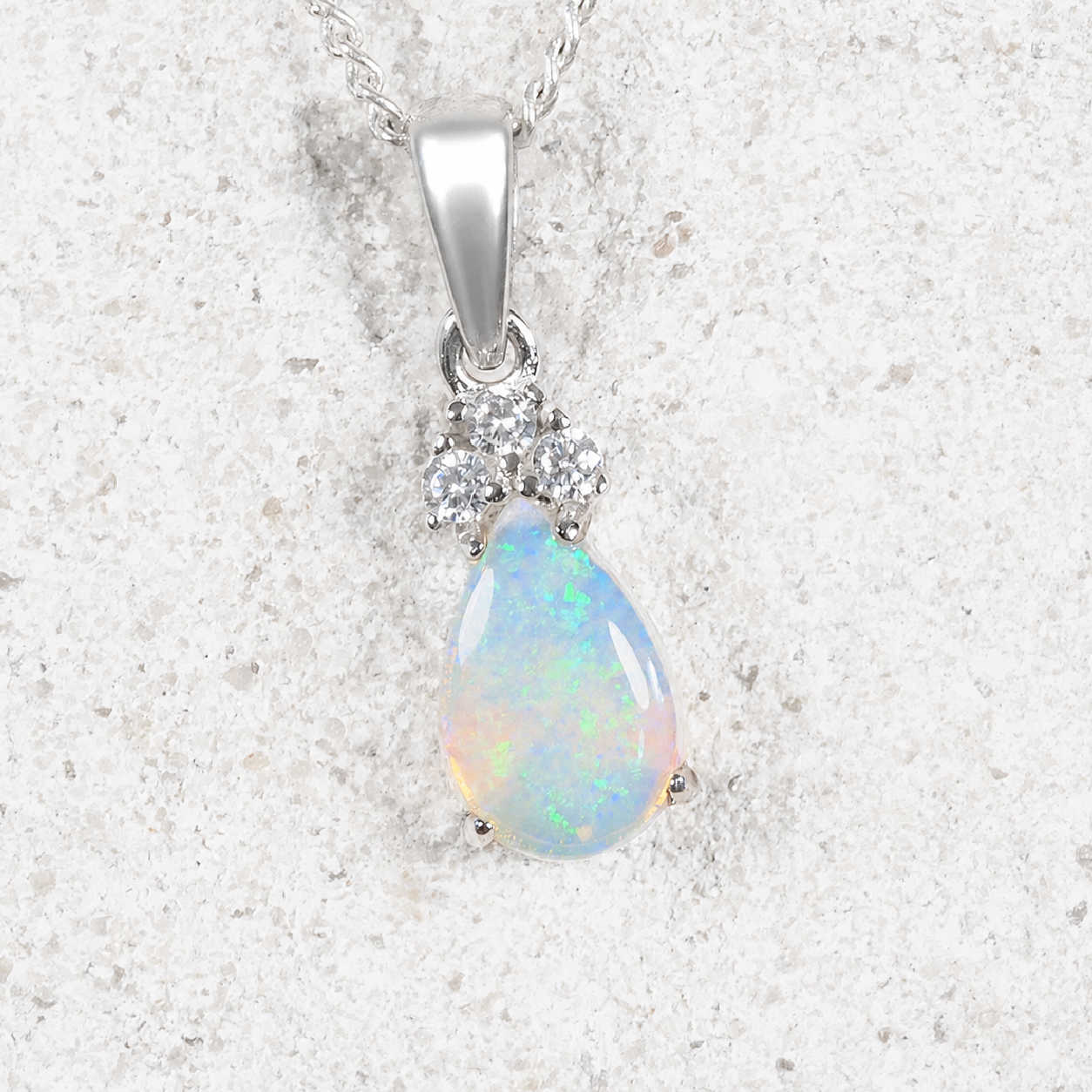 Blue opal pendant necklace on a textured white background