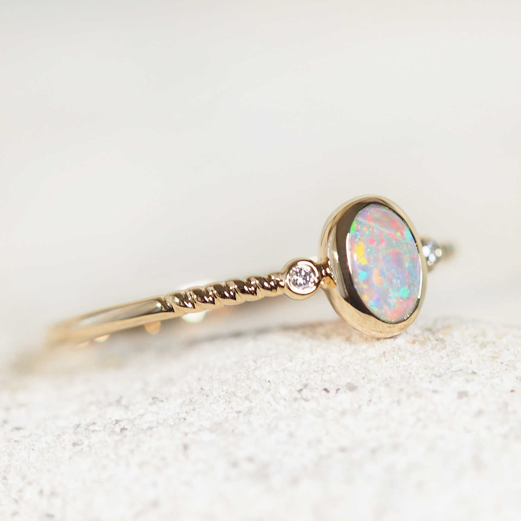 Close-up of multi-colour Australian crystal opal ring with twist band design