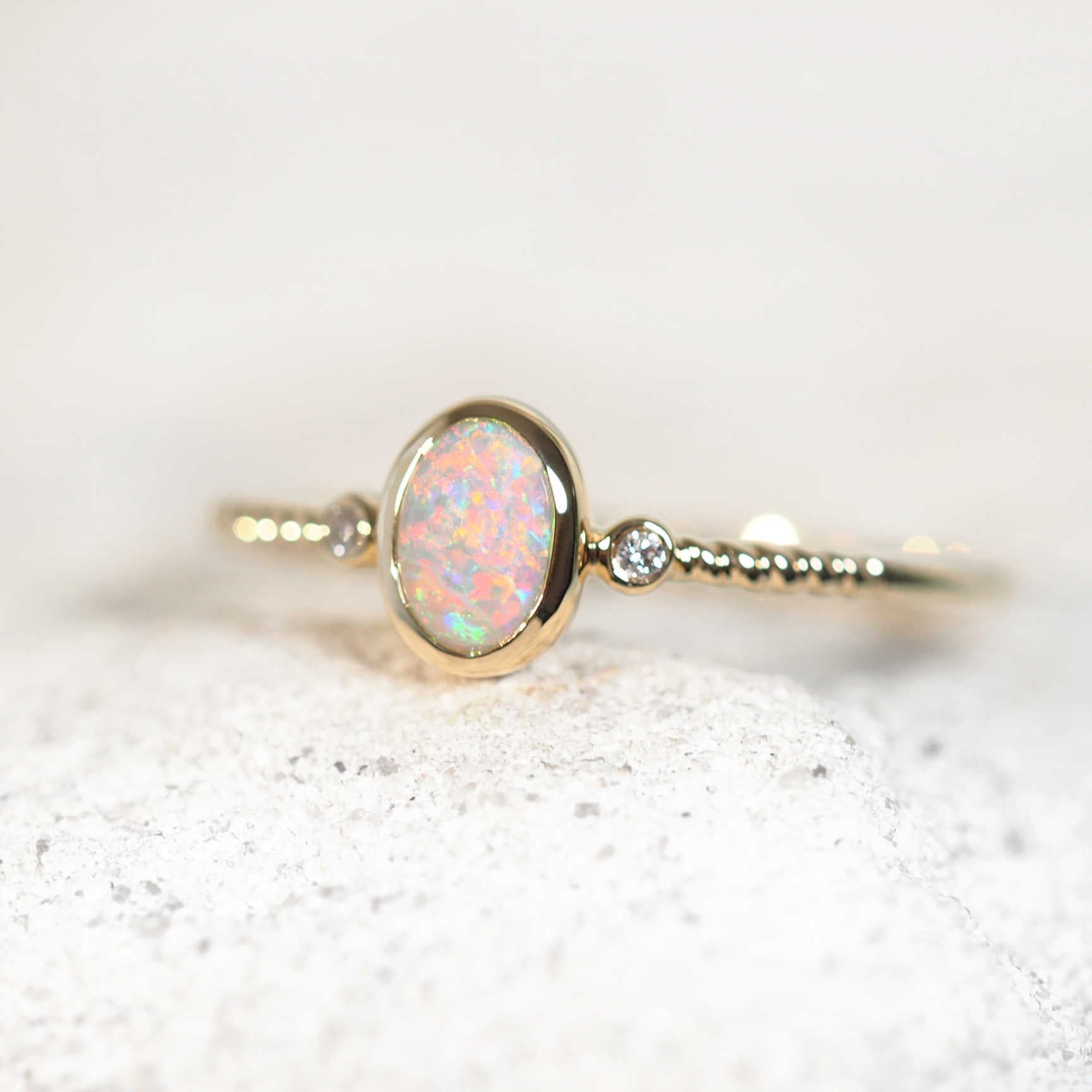 14ct yellow gold ring featuring bezel-set opal and two shoulder diamonds
