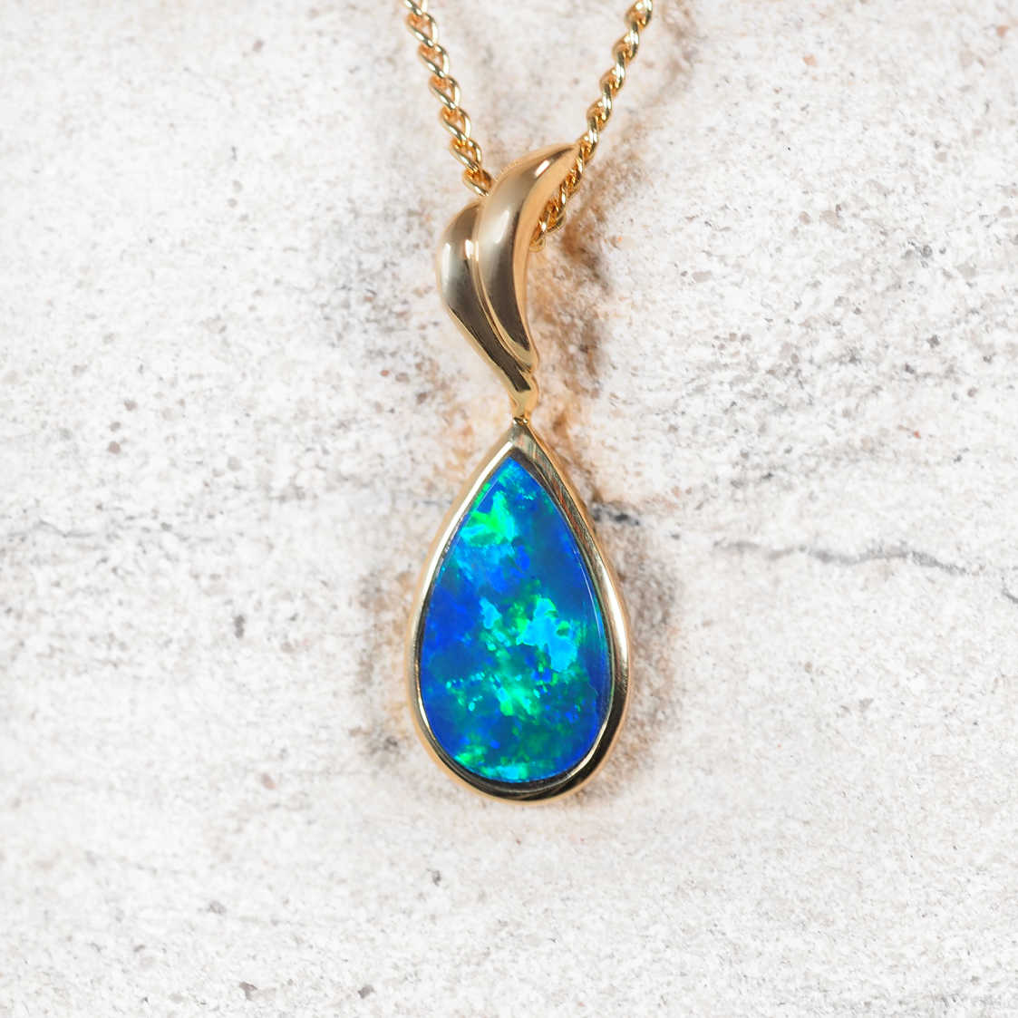 Opal pendant necklace on a light gray background