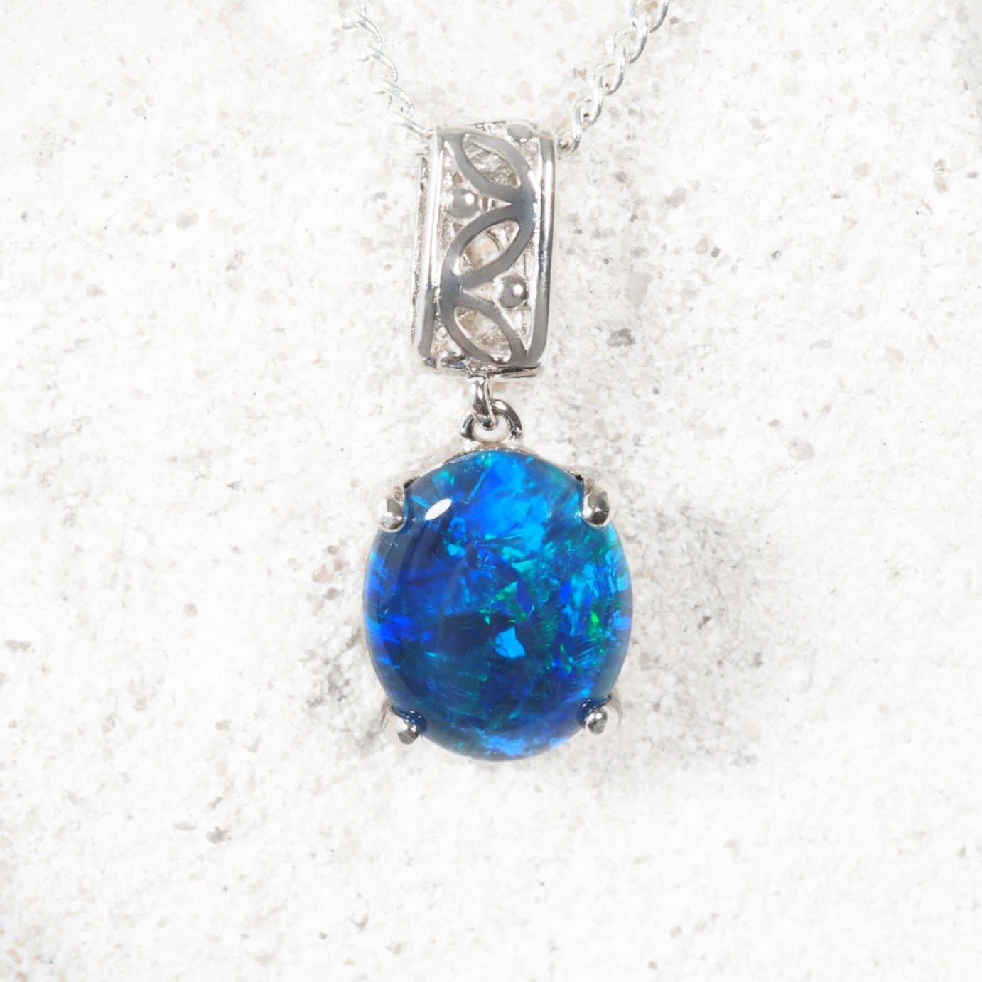 Blue opal pendant on a silver chain against a white background