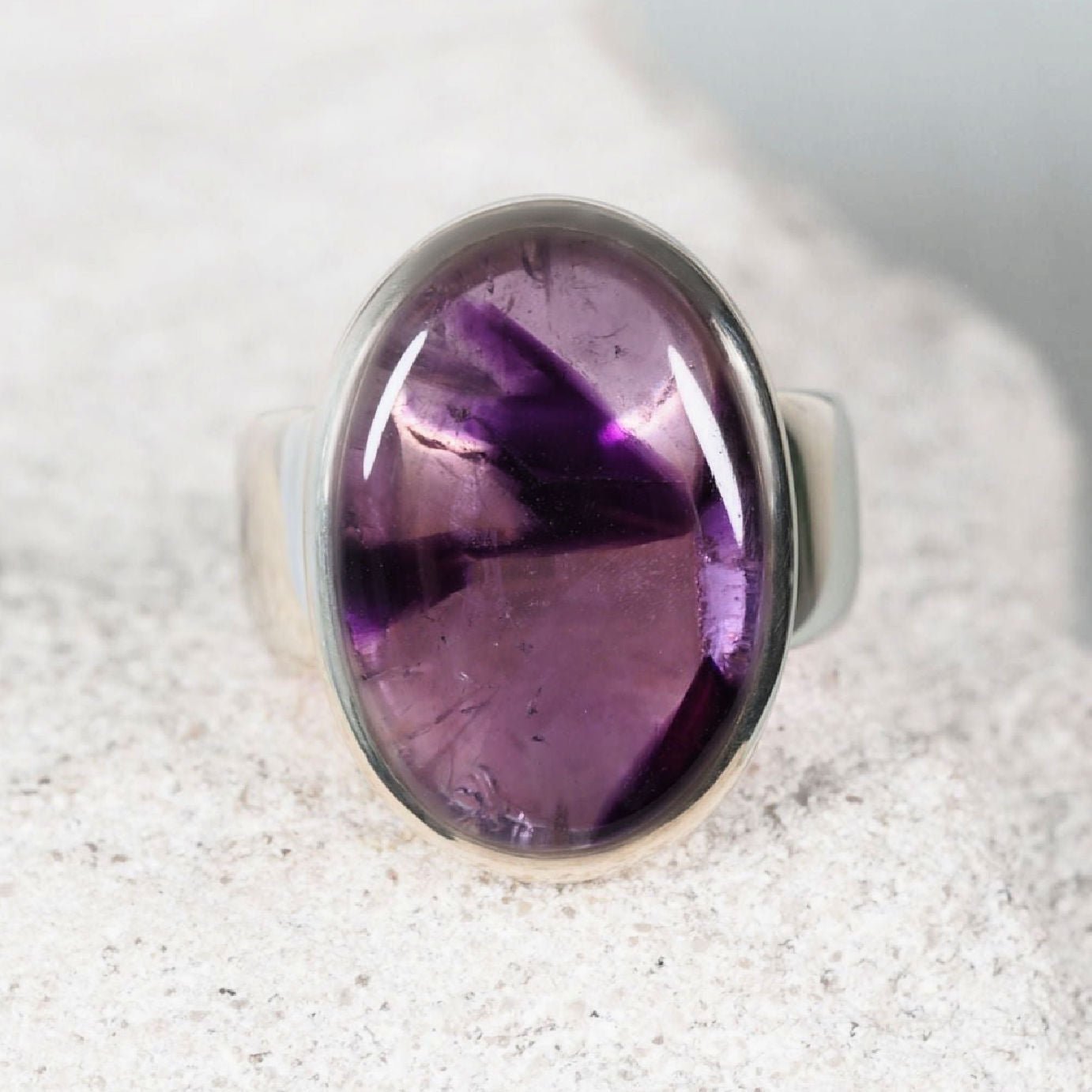 The ‘Ella’ amethyst silver ring set with an oval amethyst cabochon in light and deep purple tones