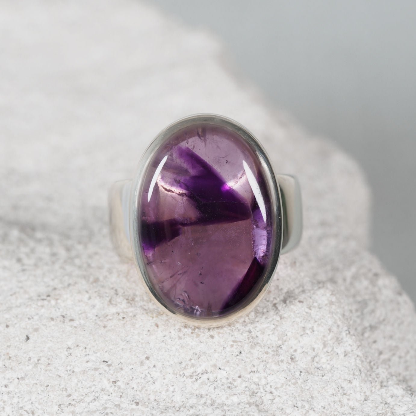 The ‘Ella’ silver ring with a circular amethyst cabochon in light and deep purple tones
