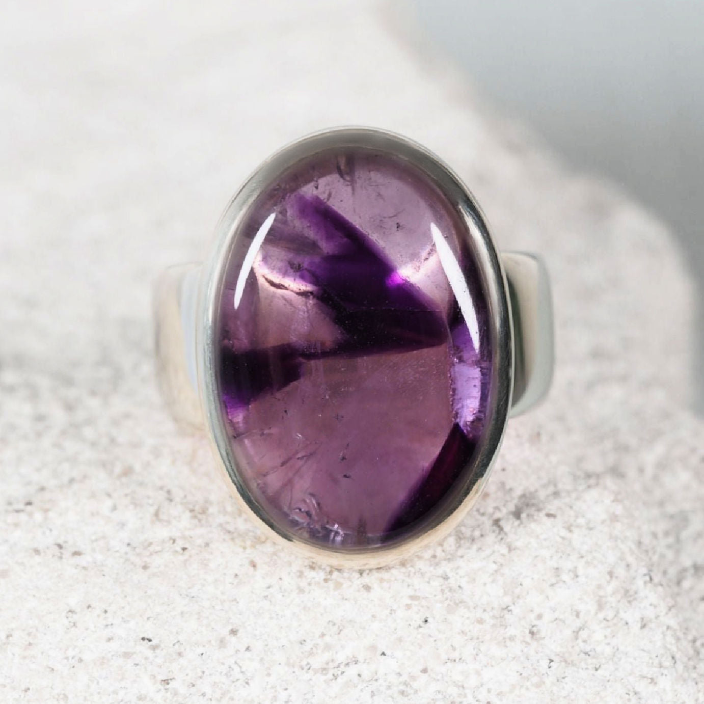 The ‘Ella’ amethyst silver ring set with an oval amethyst cabochon in light and deep purple tones