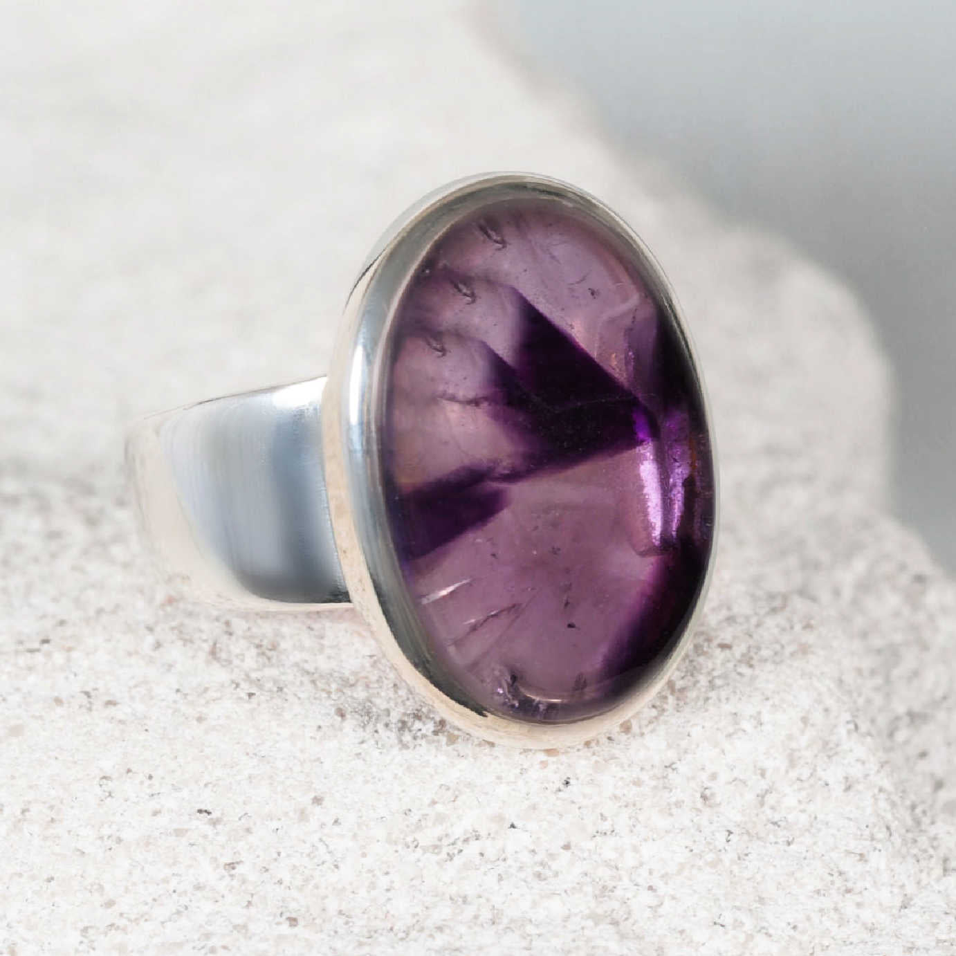 Elegant amethyst silver ring featuring a smooth oval amethyst cabochon with soft and deep purple shades
