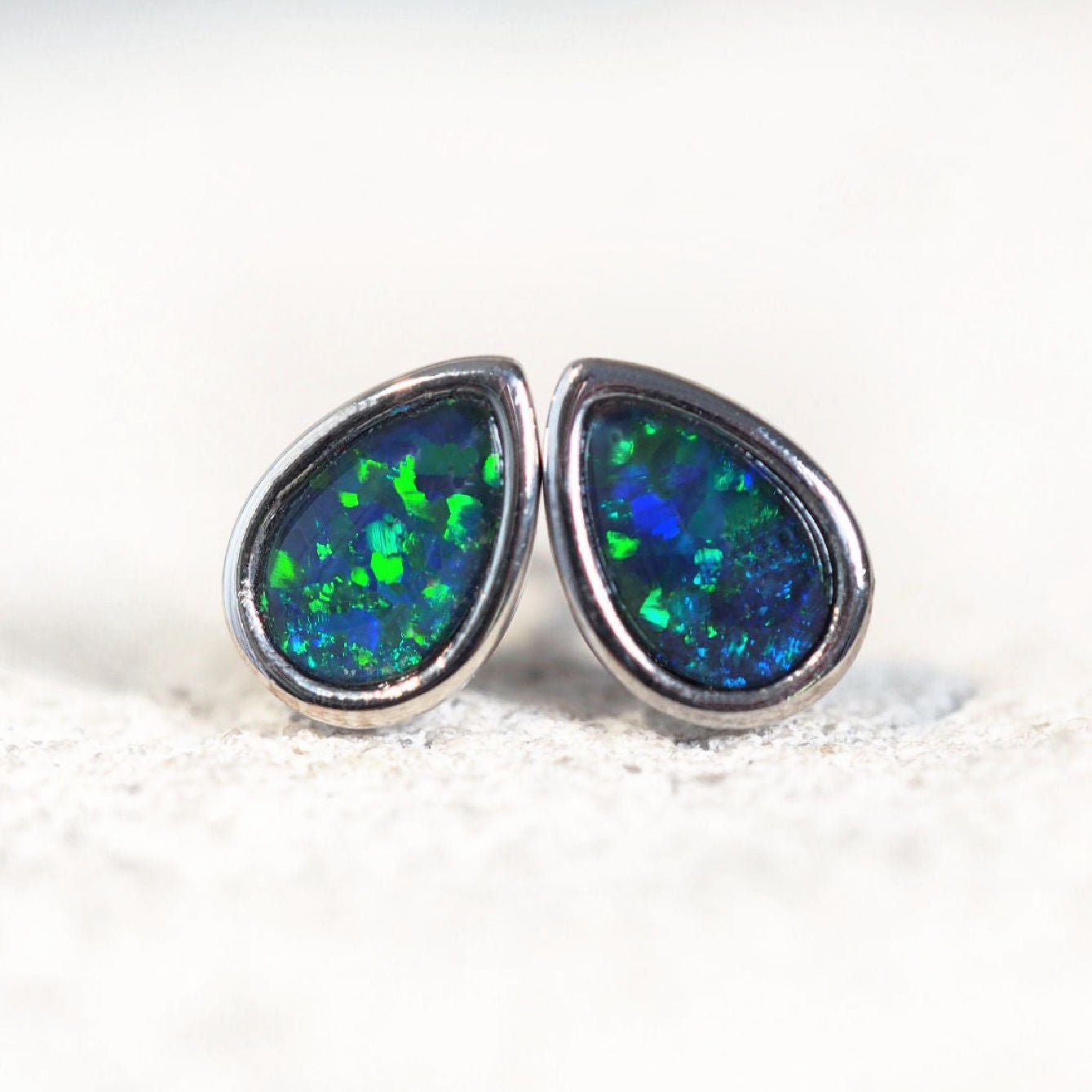 stud opal earrings set with blue and green opals