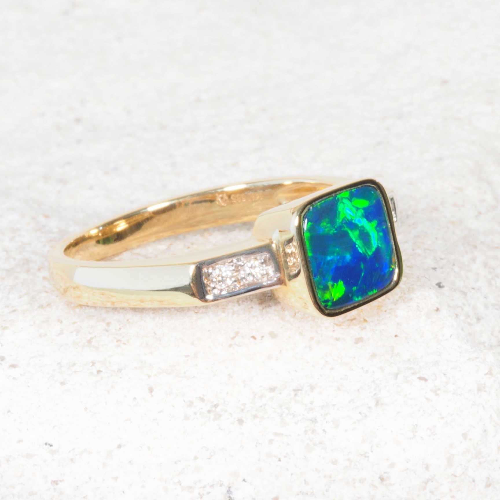 Contemporary opal ring featuring square bezel-set opal and sparkling diamonds