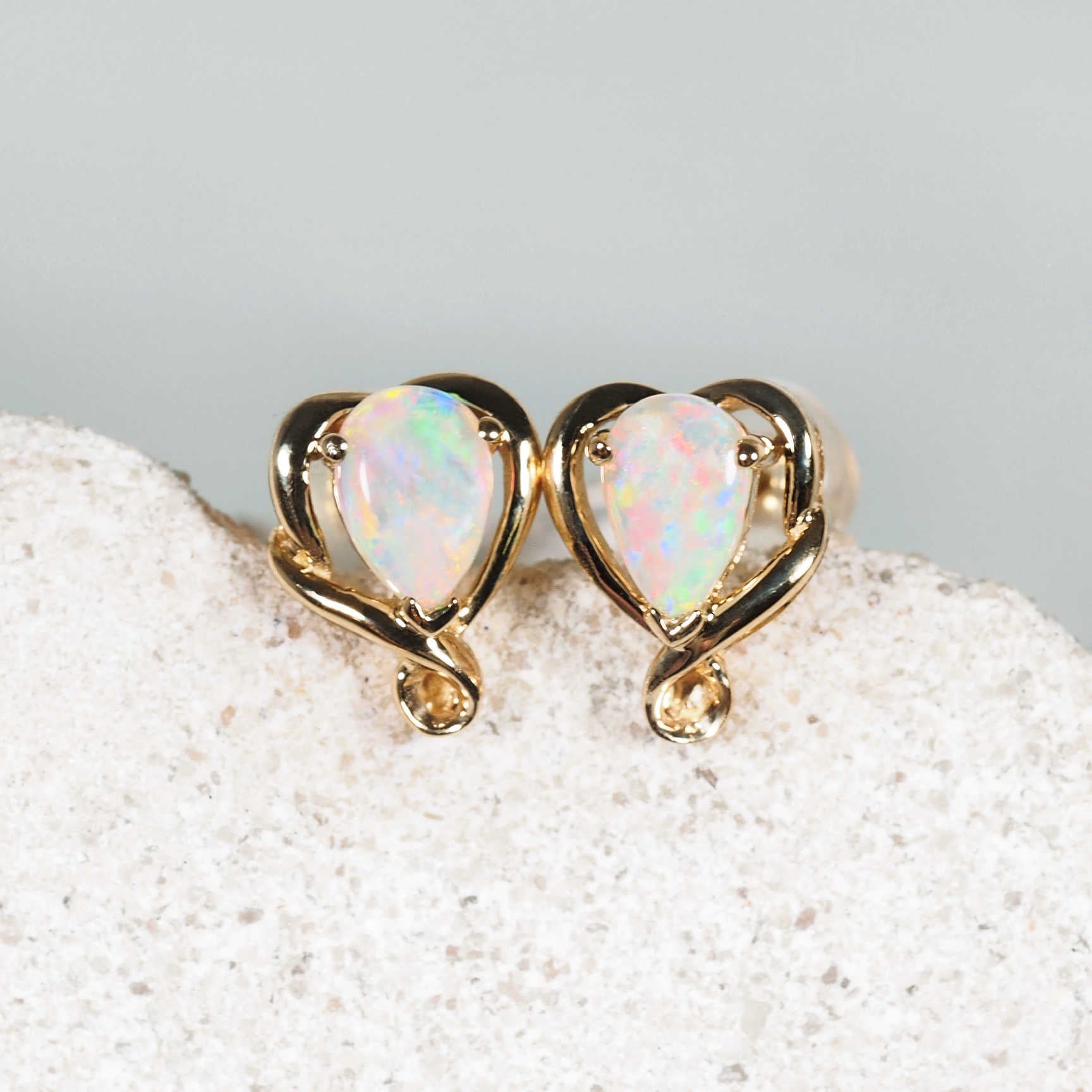 Teardrop-shaped Australian crystal opal stud earrings set in 14ct yellow gold