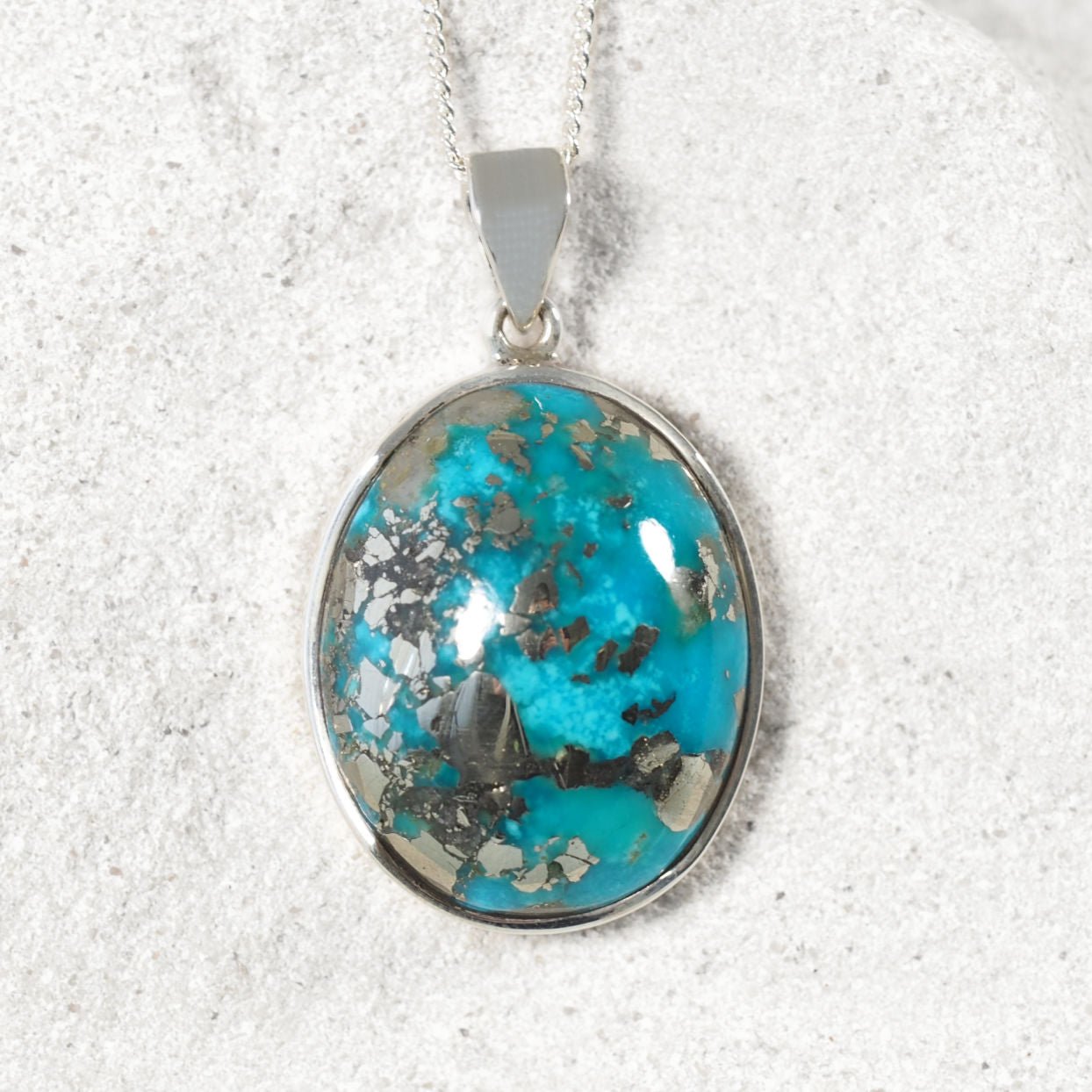Close-up of 'Eva' pendant highlighting sky-blue Persian Turquoise and sleek silver bezel