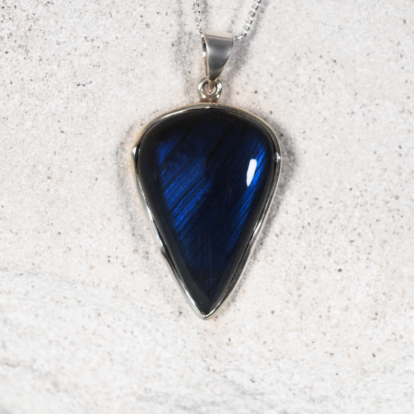 The 'Evie' Labradorite pendant with inverted teardrop stone set in polished silver, showing blue flashes