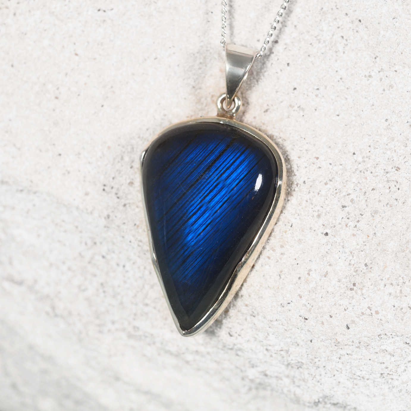 Close-up of 'Evie' pendant highlighting the shimmering Indian Labradorite in a silver frame