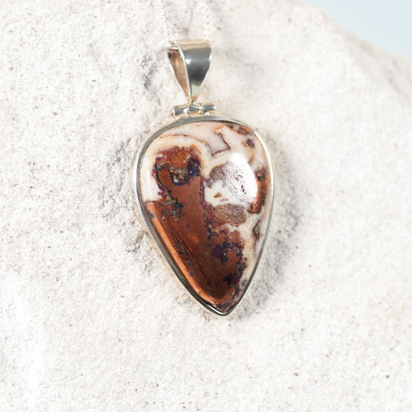 Upside-down teardrop Copper Dolomite pendant set in a sleek silver frame, showcasing white, copper, and brown hues