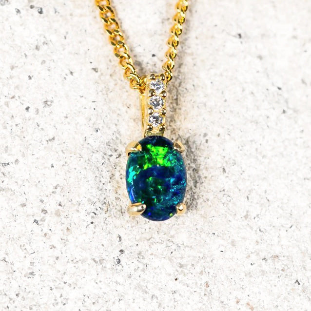 Gold-plated silver opal pendant with an oval blue and green Australian triplet opal and three cubic zirconias.