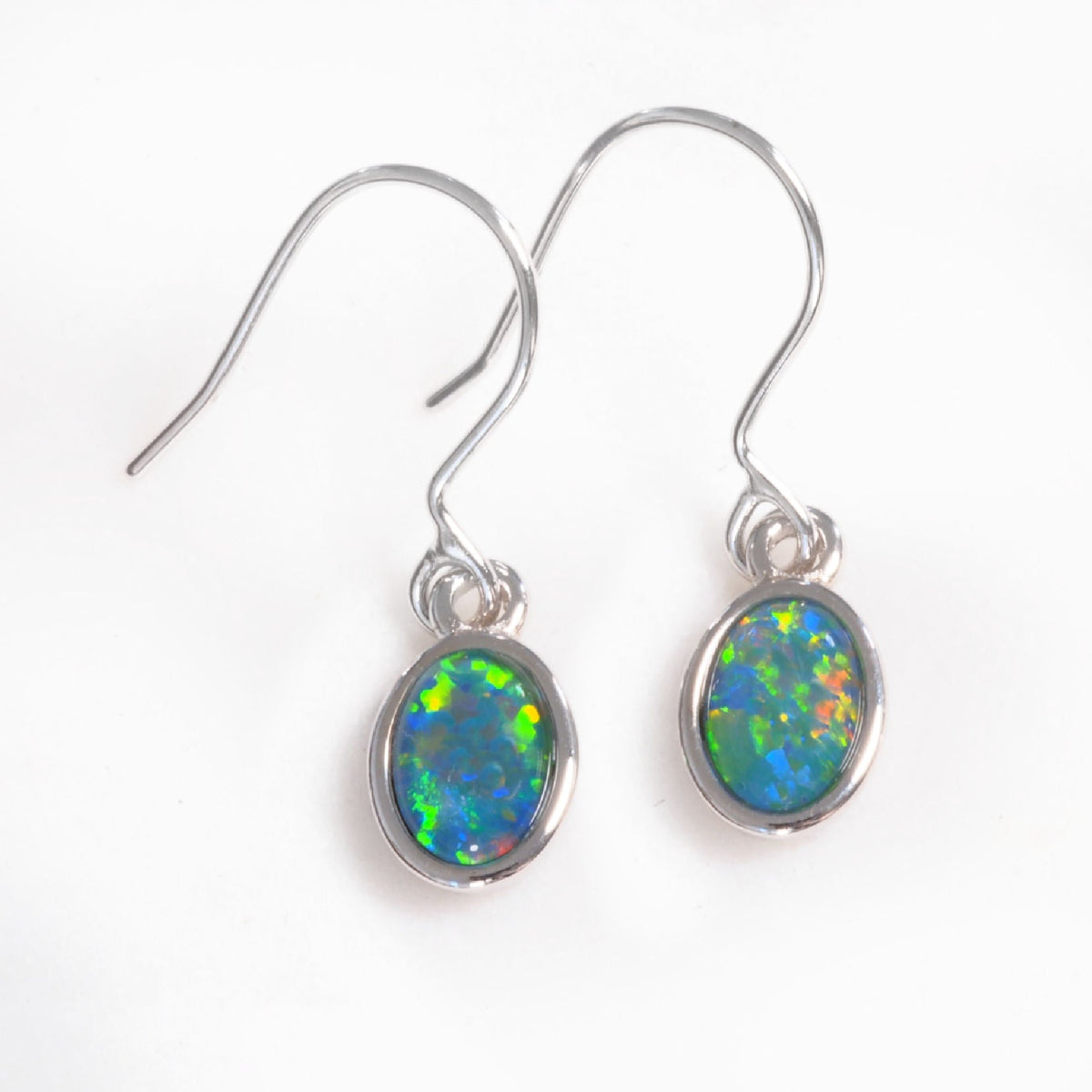 A pair of silver opal drop earrings with oval opal gemstones, displayed on a clean white background.