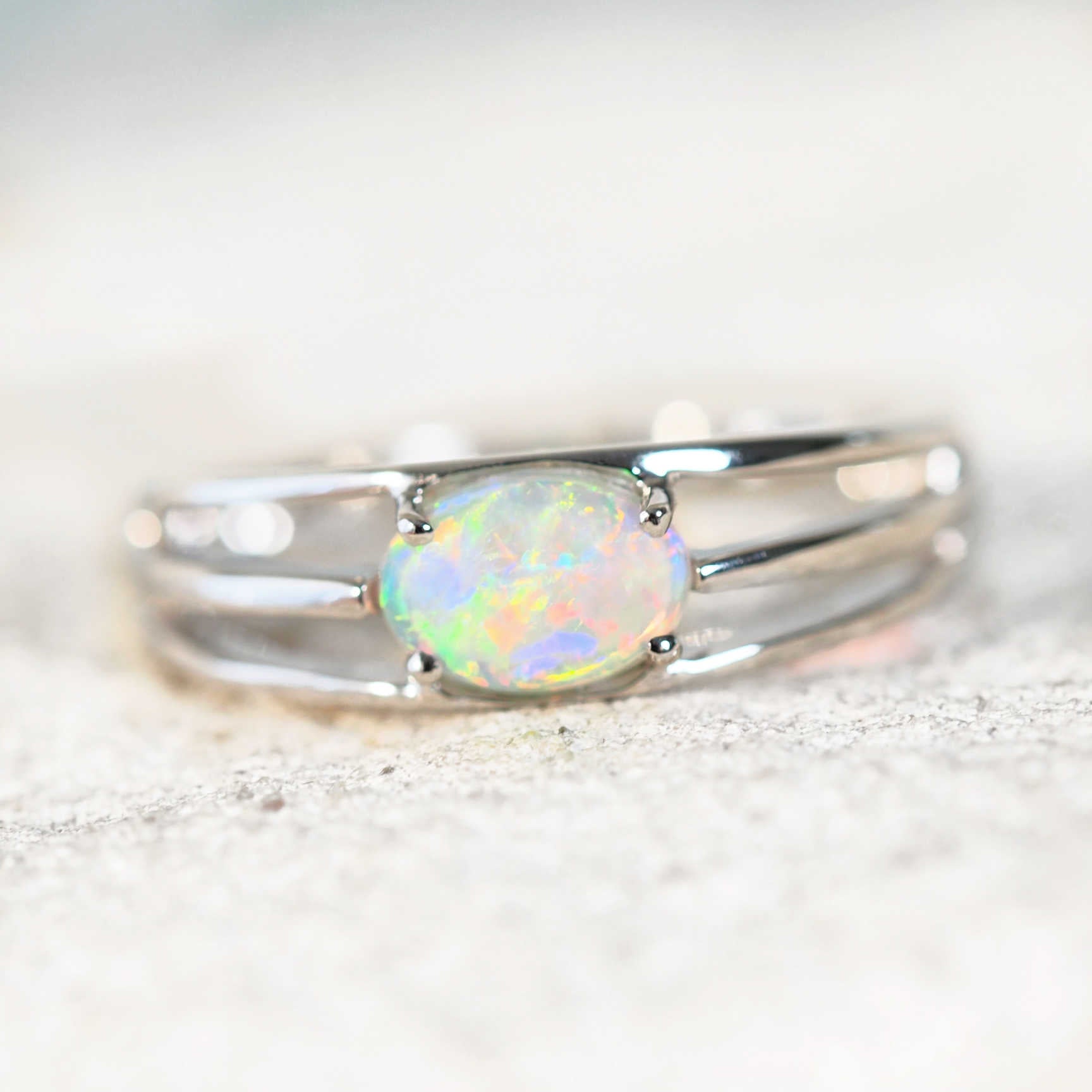 vibrant crystal opal ring set in white gold with a tri band