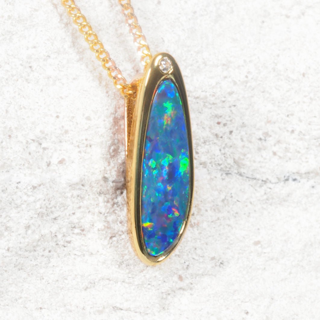 Opal pendant necklace on a gold chain against a white background