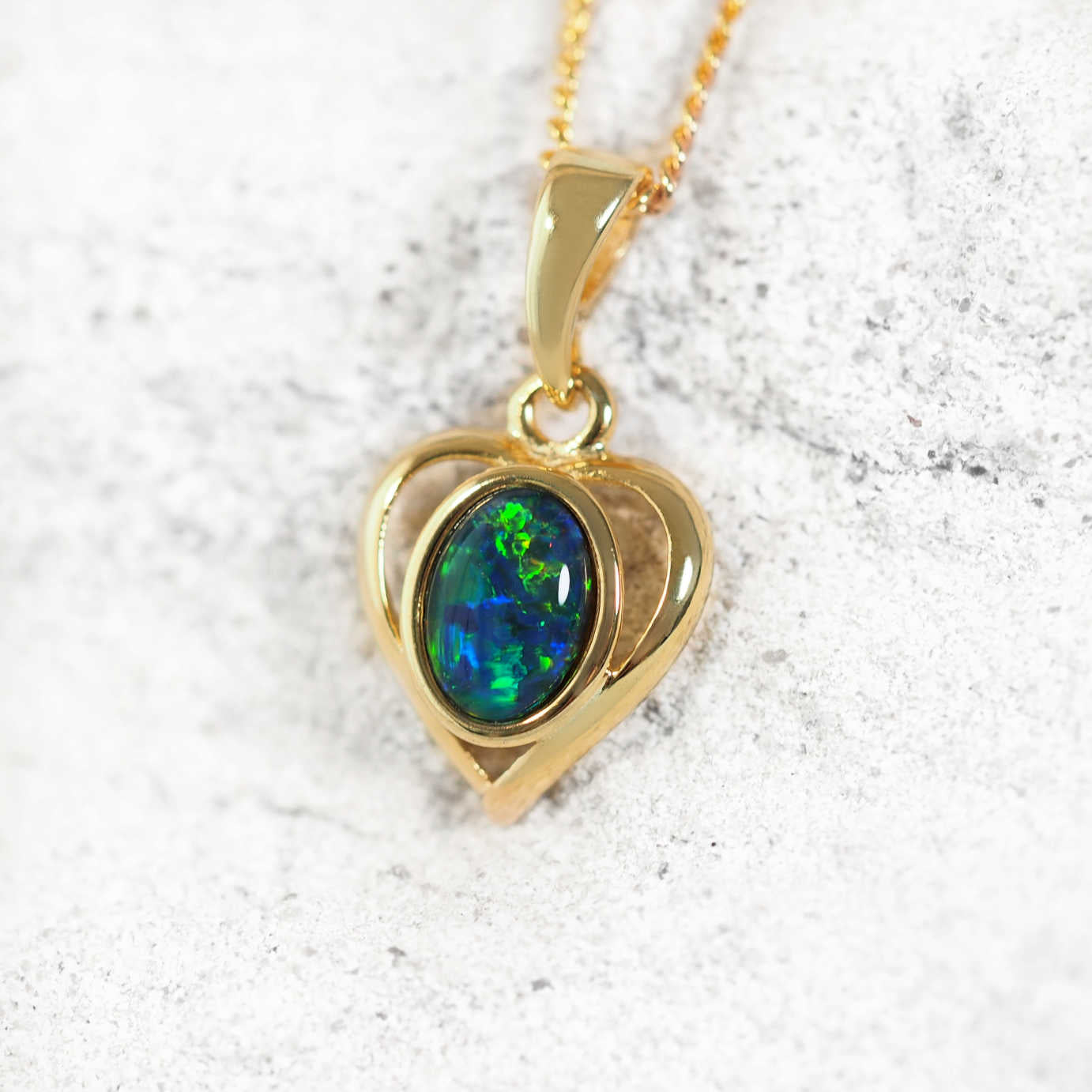 Heart Blue opal pendant in gold-plated silver with heart design and claw-set oval Australian triplet opal in blue and green hues