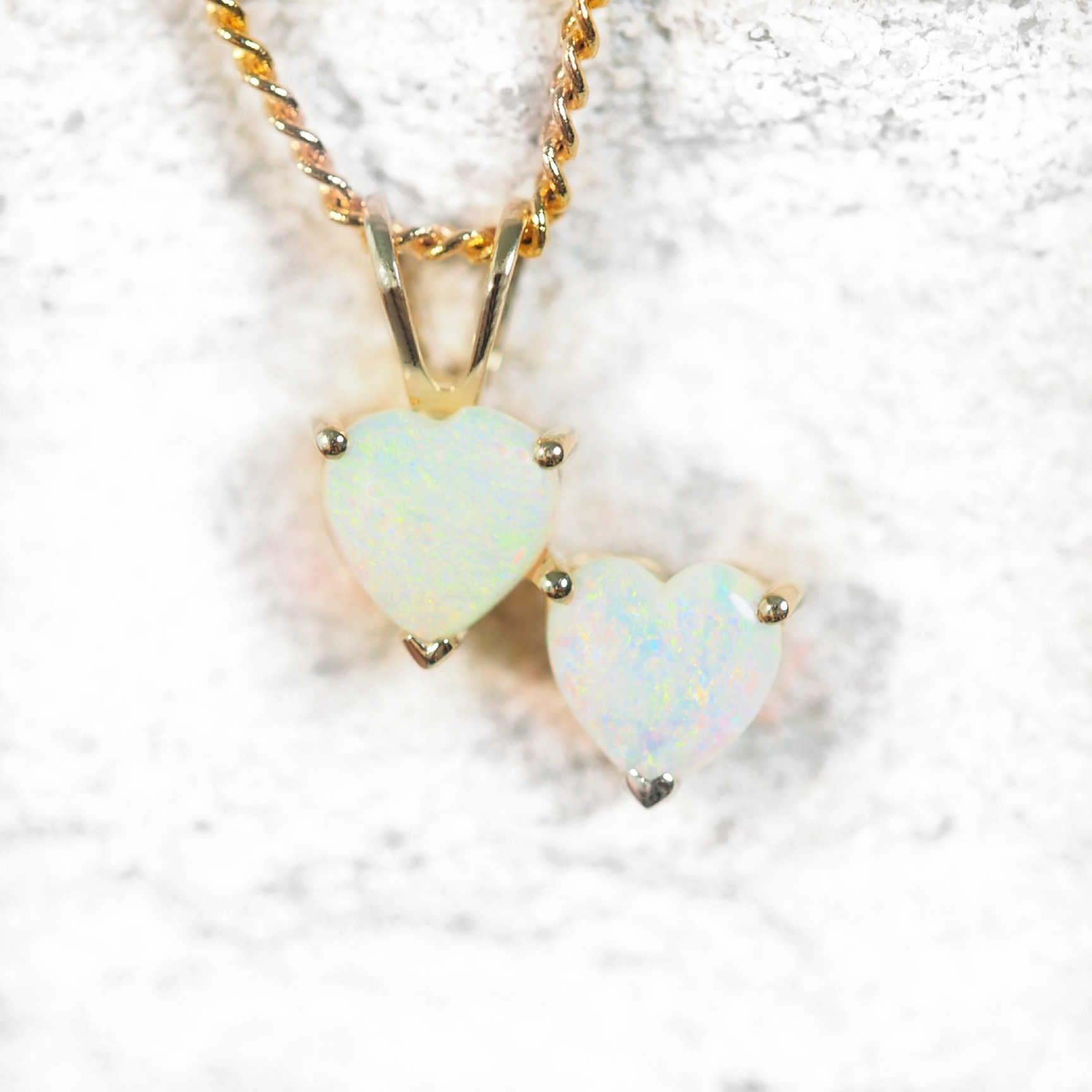 Gold opal pendant with two heart-shaped floral-patterned crystal opals