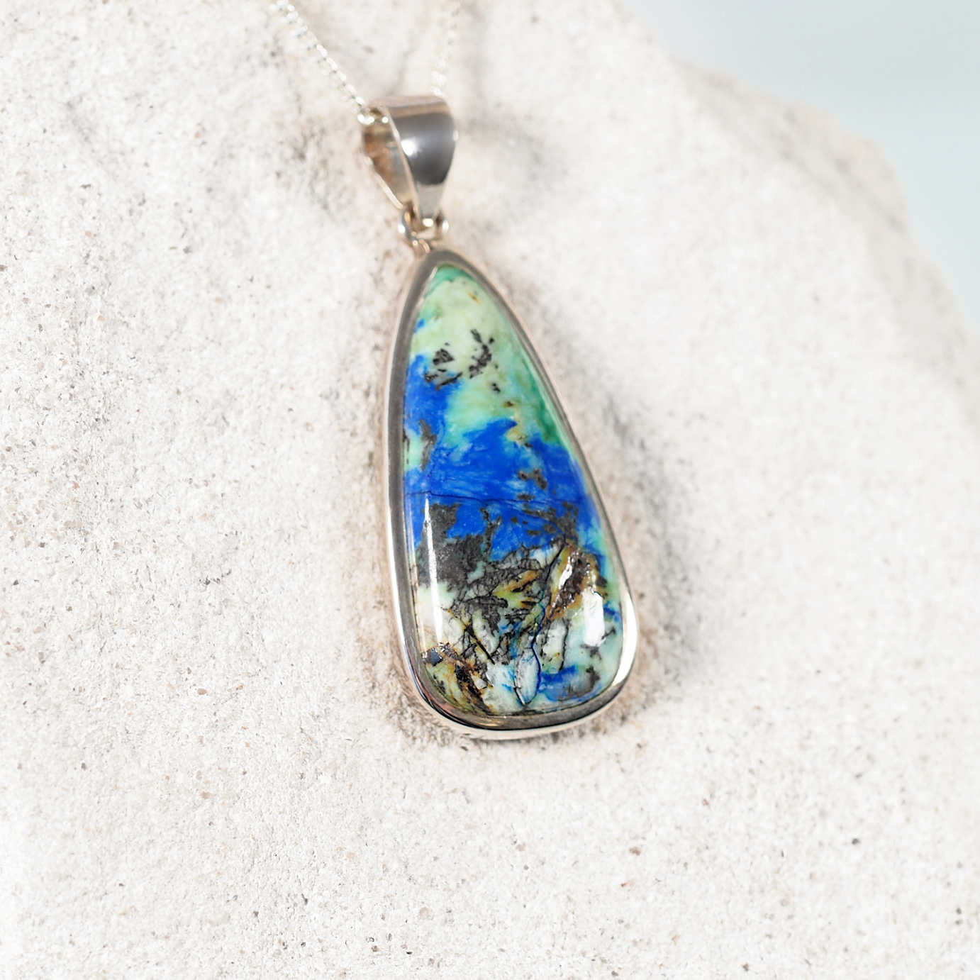 Close-up of 'Hope' pendant highlighting blue-green Azurite/Chrysocolla gemstone in silver frame