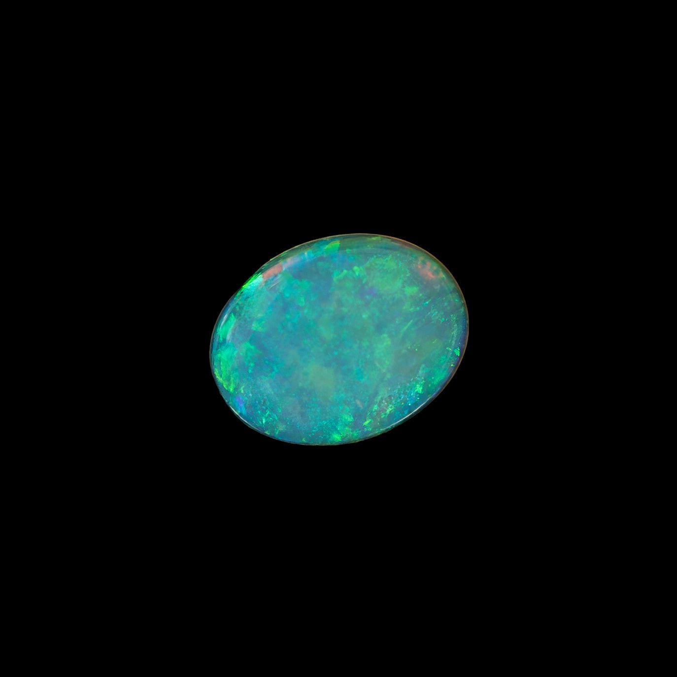 Oval-shaped Coober Pedy crystal opal with green and gold flashes