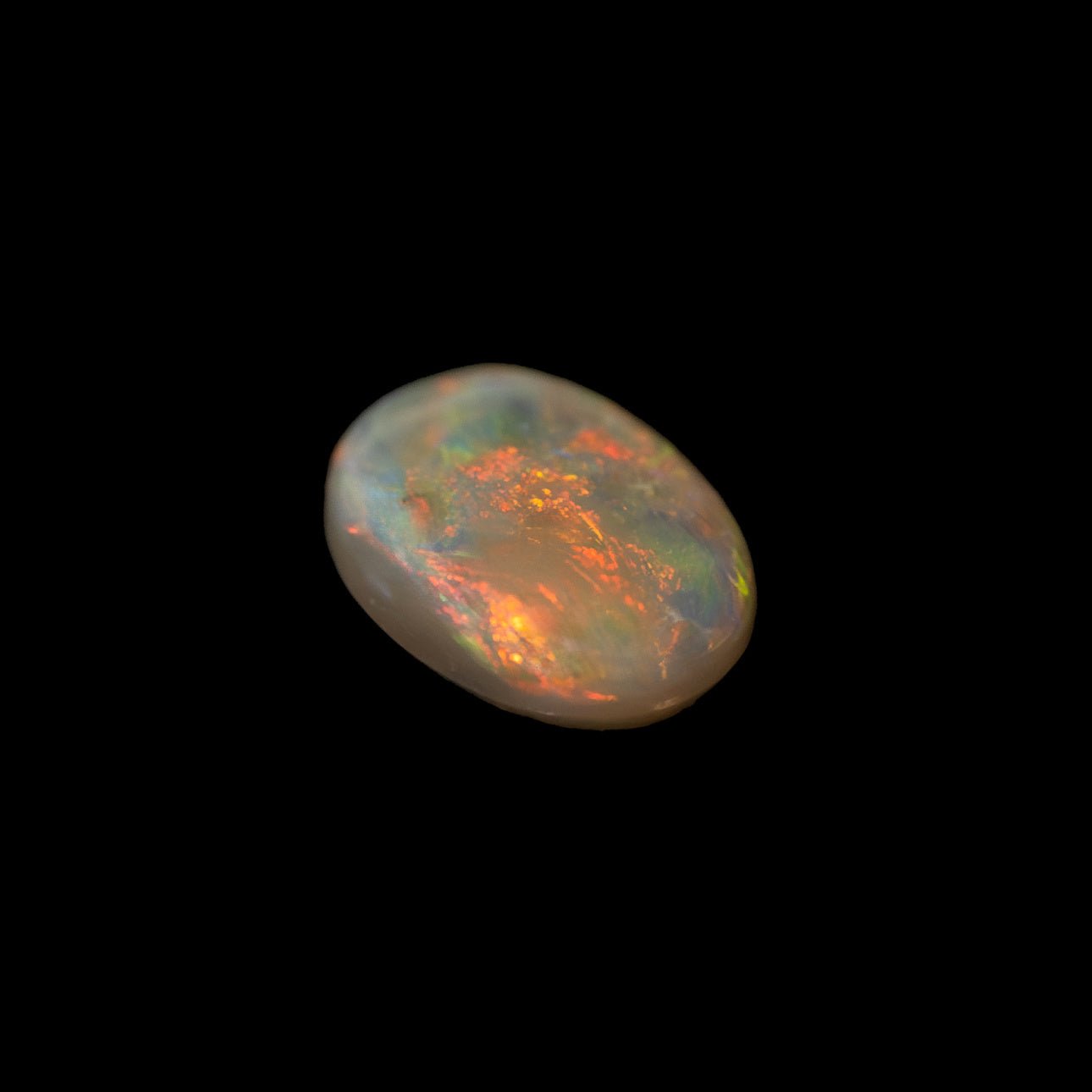 Oval-shaped black opal from Lightning Ridge with vivid red and multi-colour fire