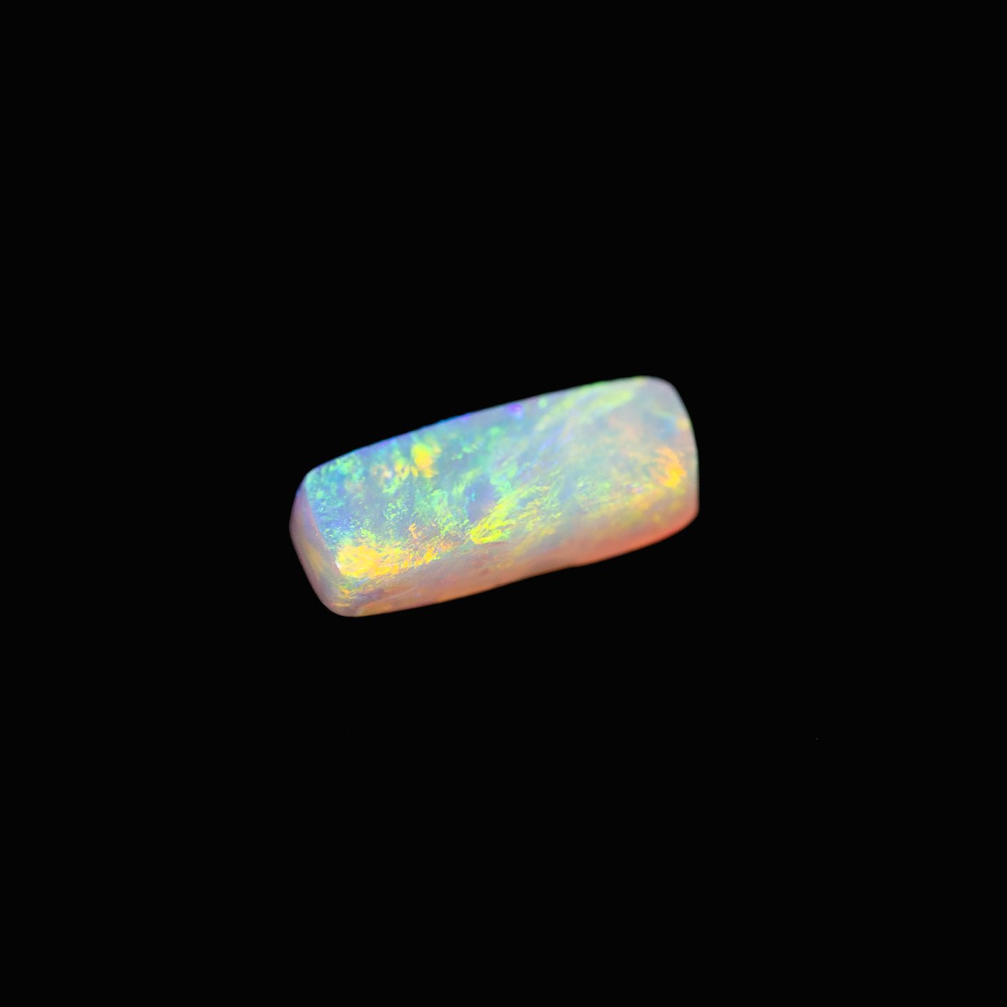 Iridesca opal showing flashes of red, green, violet, and gold on a clear body
