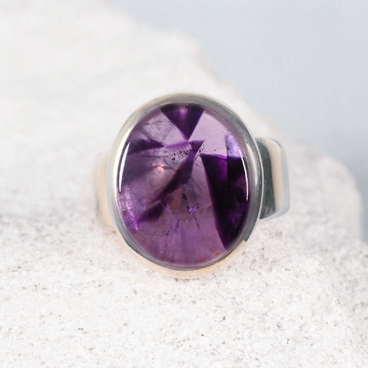 Elegant amethyst silver ring featuring a round cabochon with subtle colour variations
